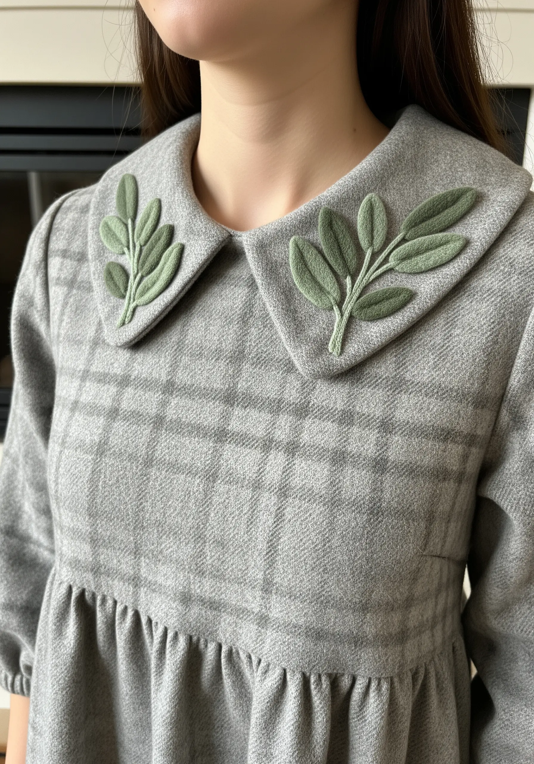 Green felt appliqué leaves with embroidered stems on the collar of a gray plaid dress.