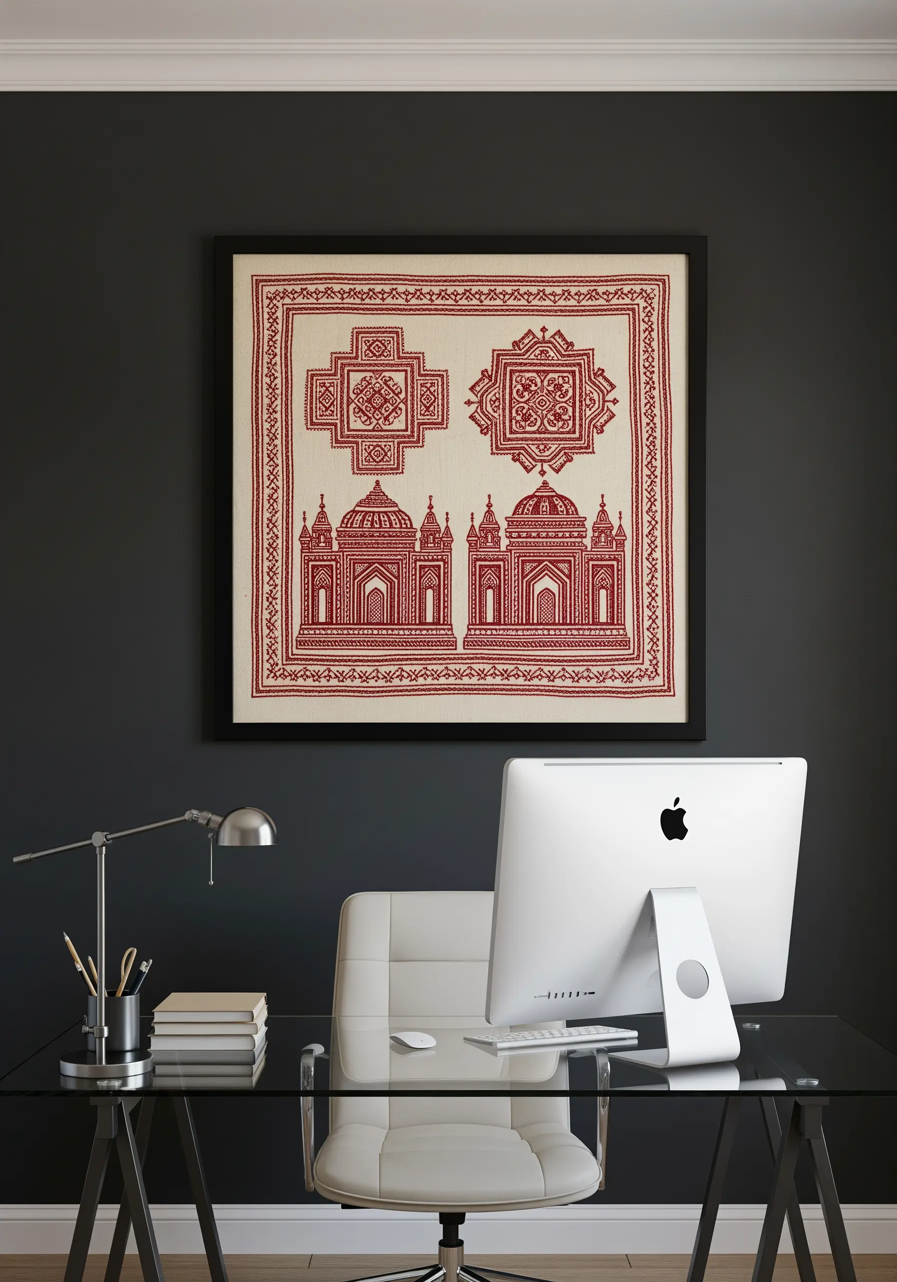 Framed red Kasuti embroidery of the Taj Mahal against a dark wall in a modern office.