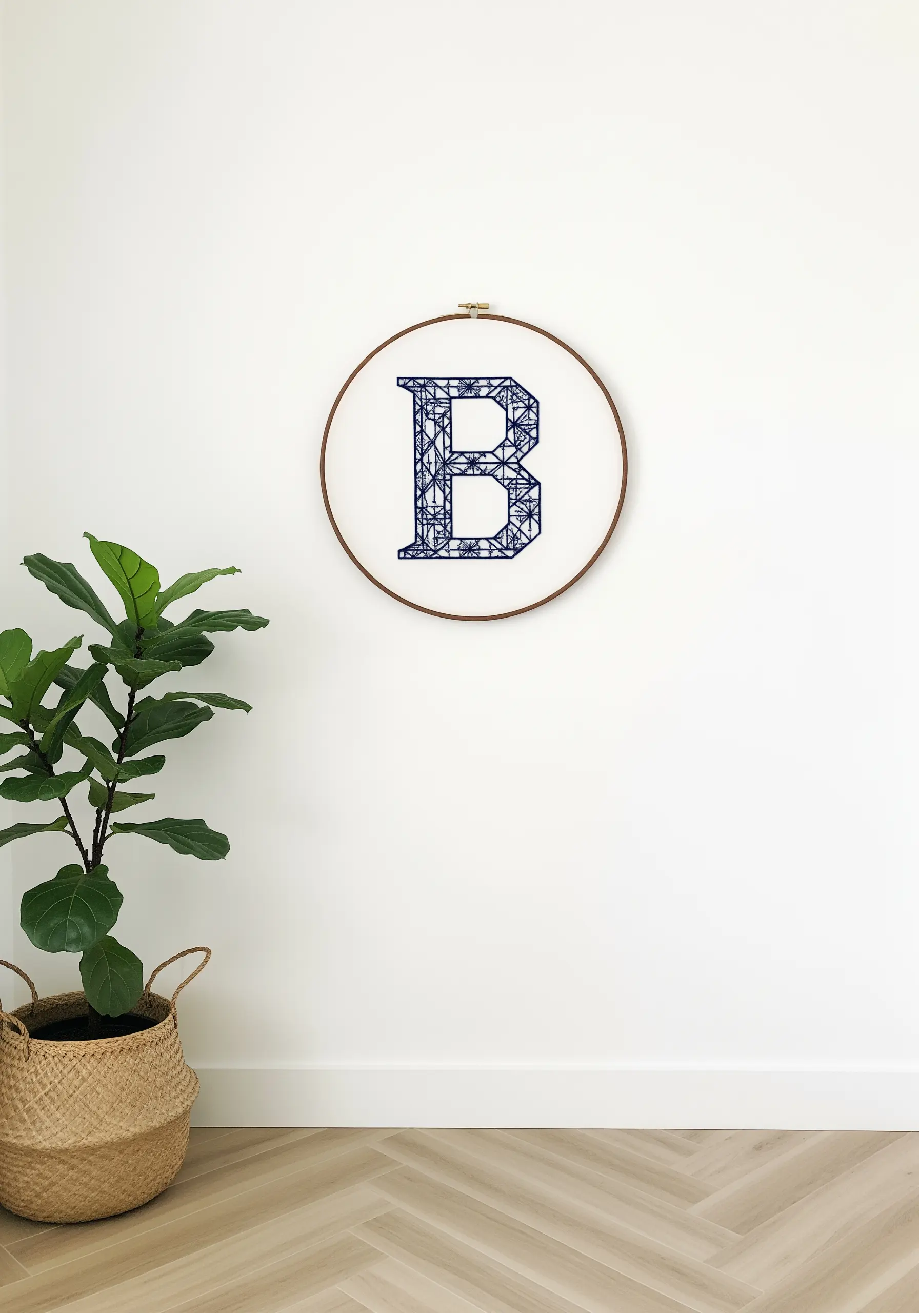 Monogram 'B' filled with an intricate blue geometric stitch pattern.