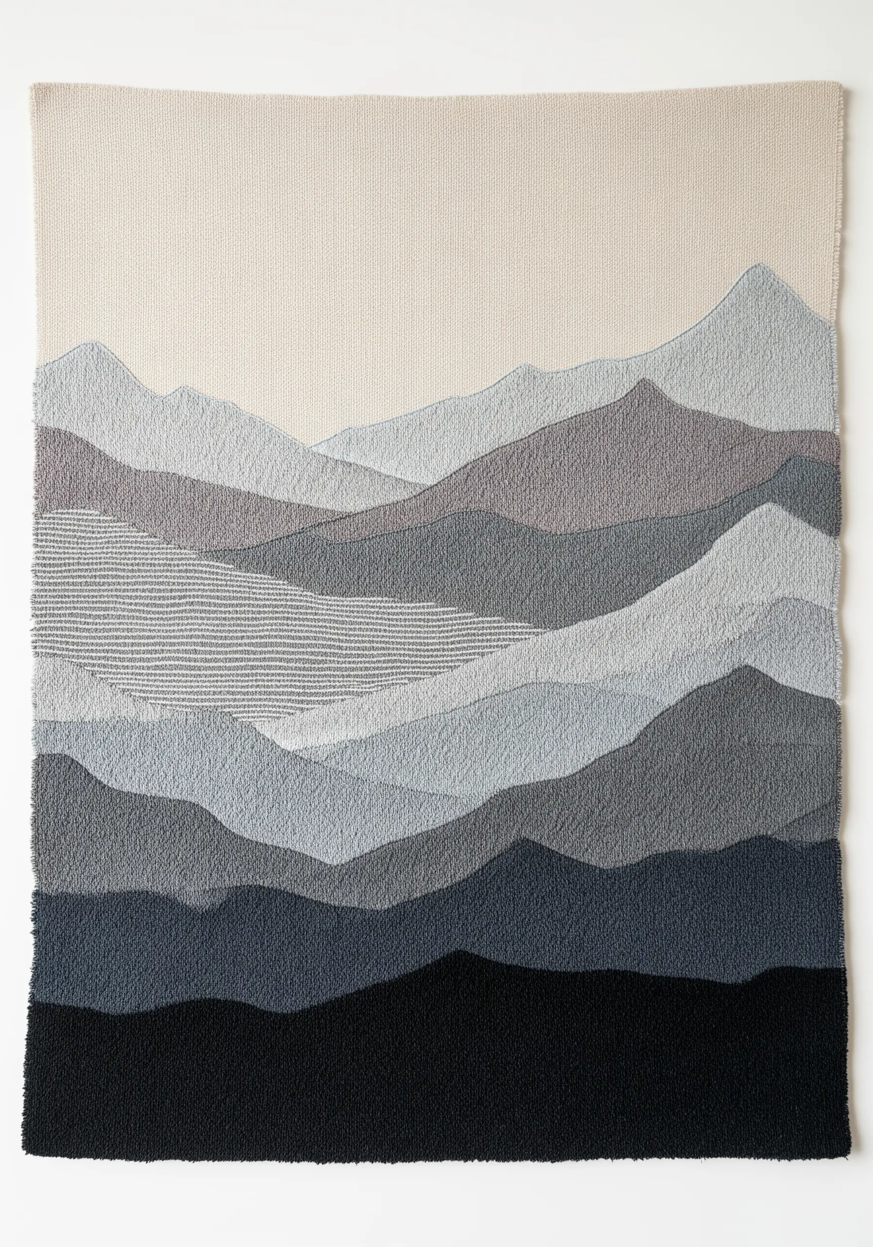 Abstract mountain landscape embroidery using various textures in shades of grey and blue.