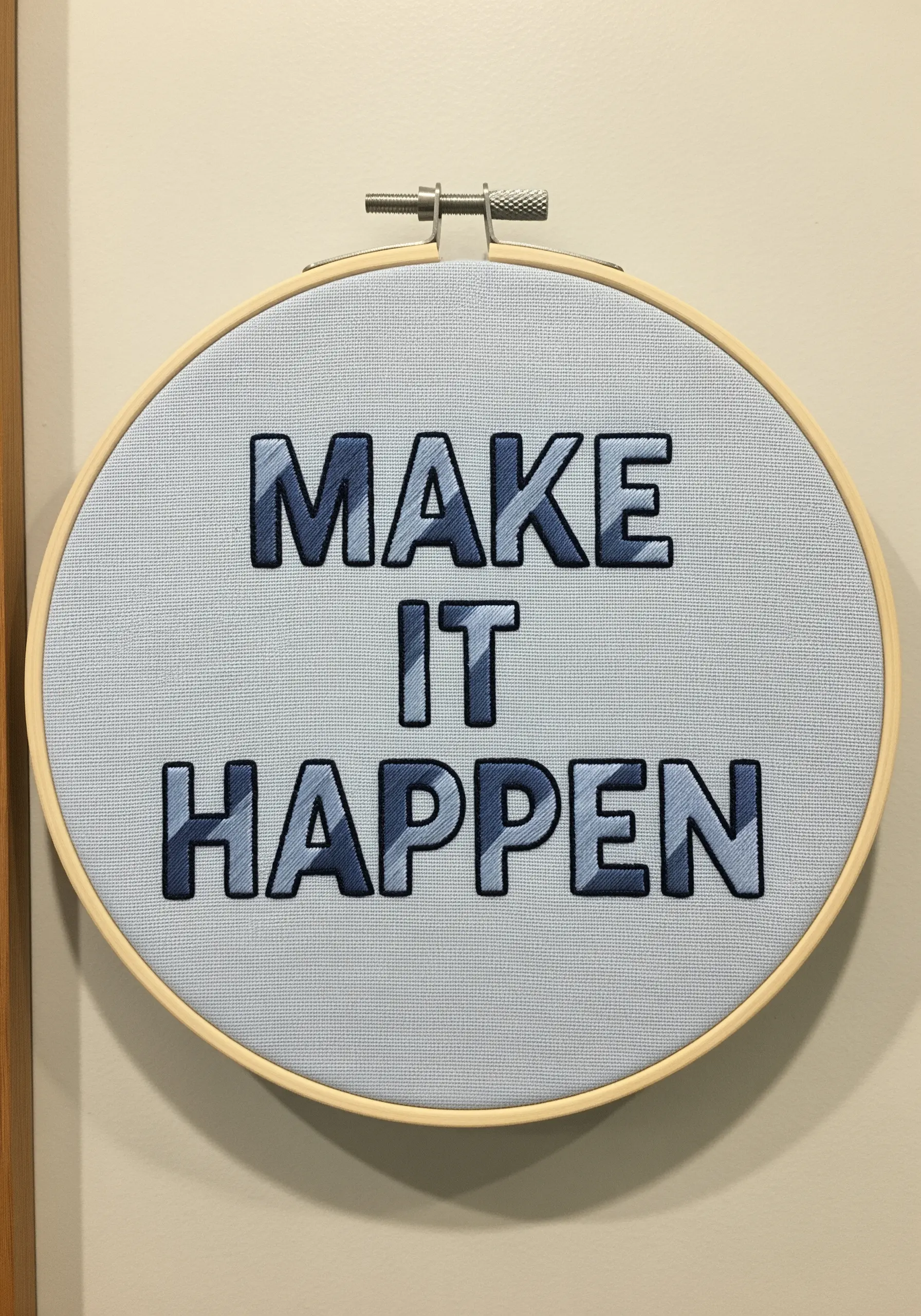 The phrase 'MAKE IT HAPPEN' embroidered with a grey gradient to create a 3D beveled effect.