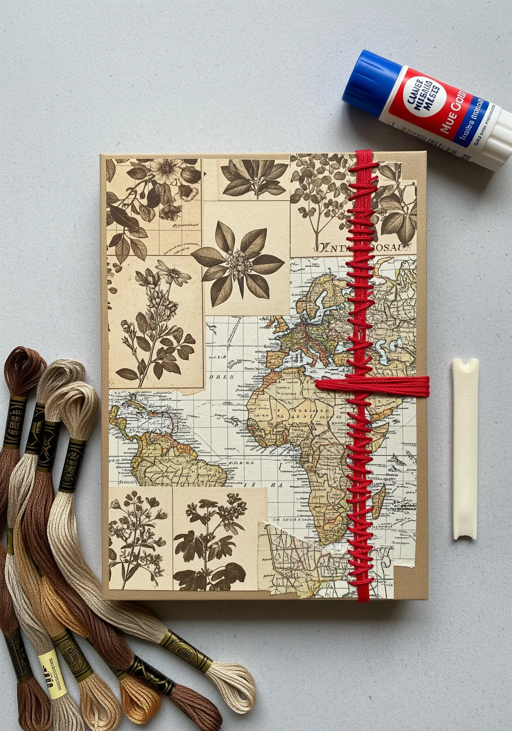 A vintage map and botanical paper collage bound with a red spine stitch.