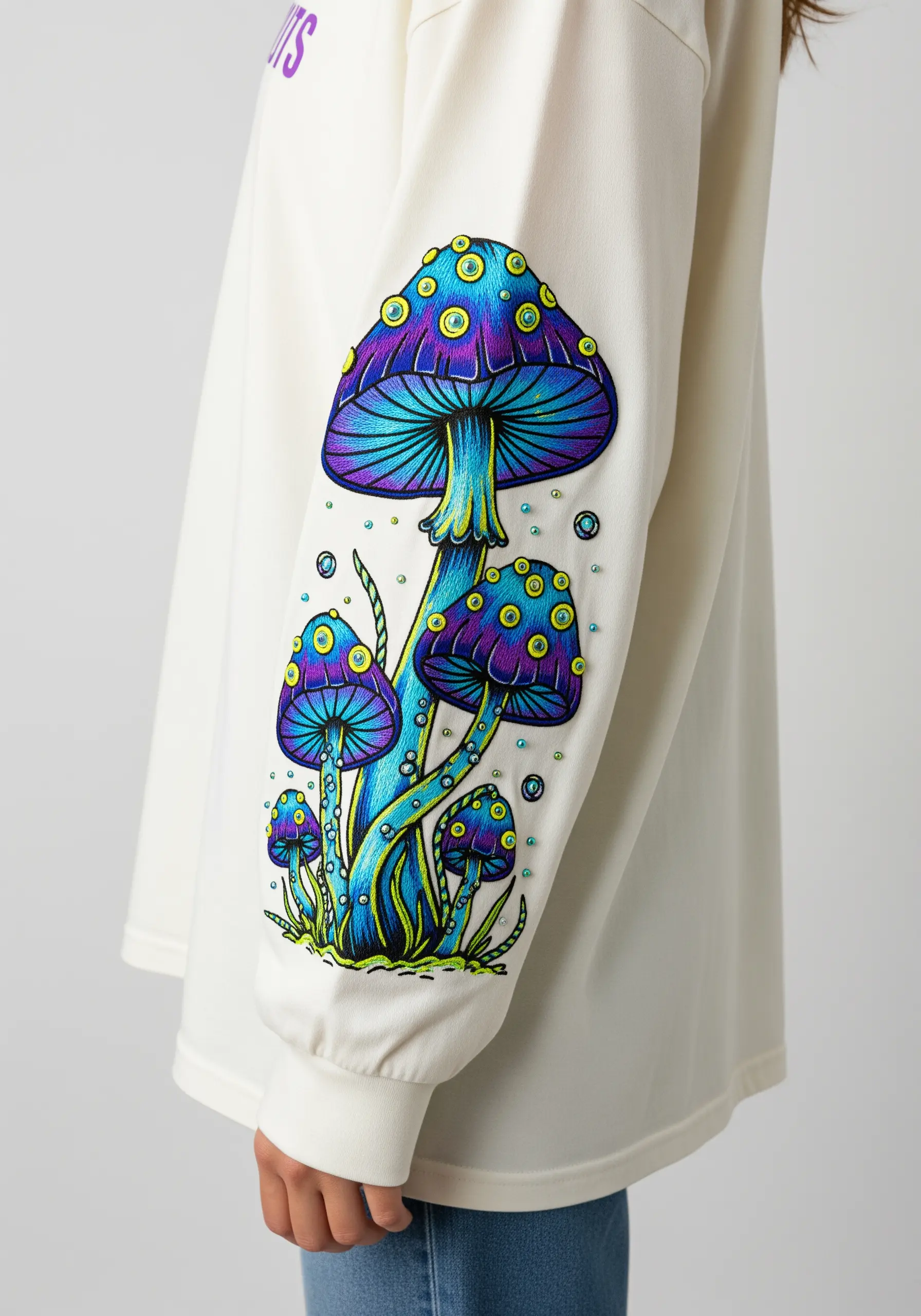 Embroidered psychedelic blue and purple mushrooms with neon green outlines on a white sleeve.