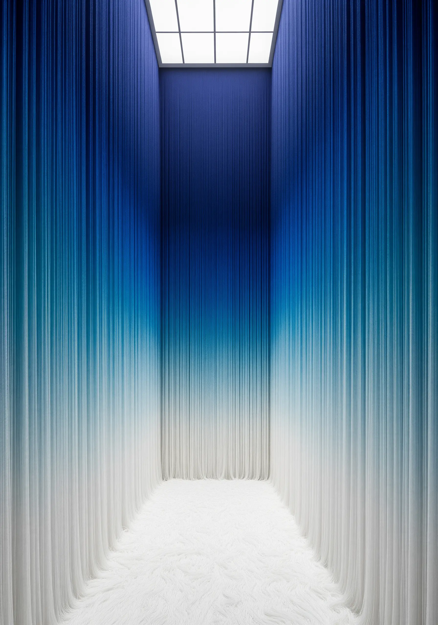 A room filled with threads hanging from the ceiling, creating a smooth color gradient from dark blue to white.