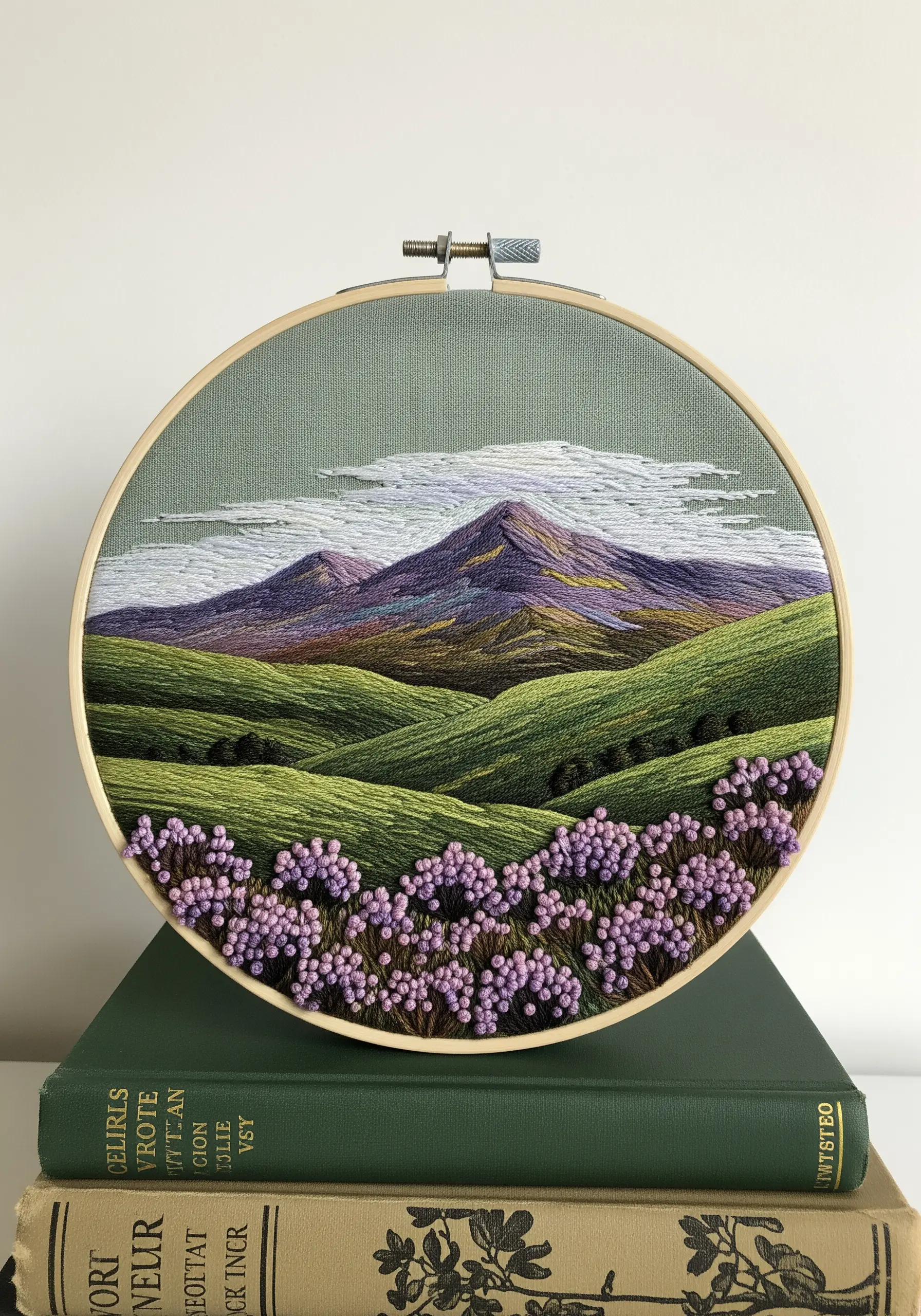 Embroidery of rolling green and purple hills with a field of textured lavender flowers.