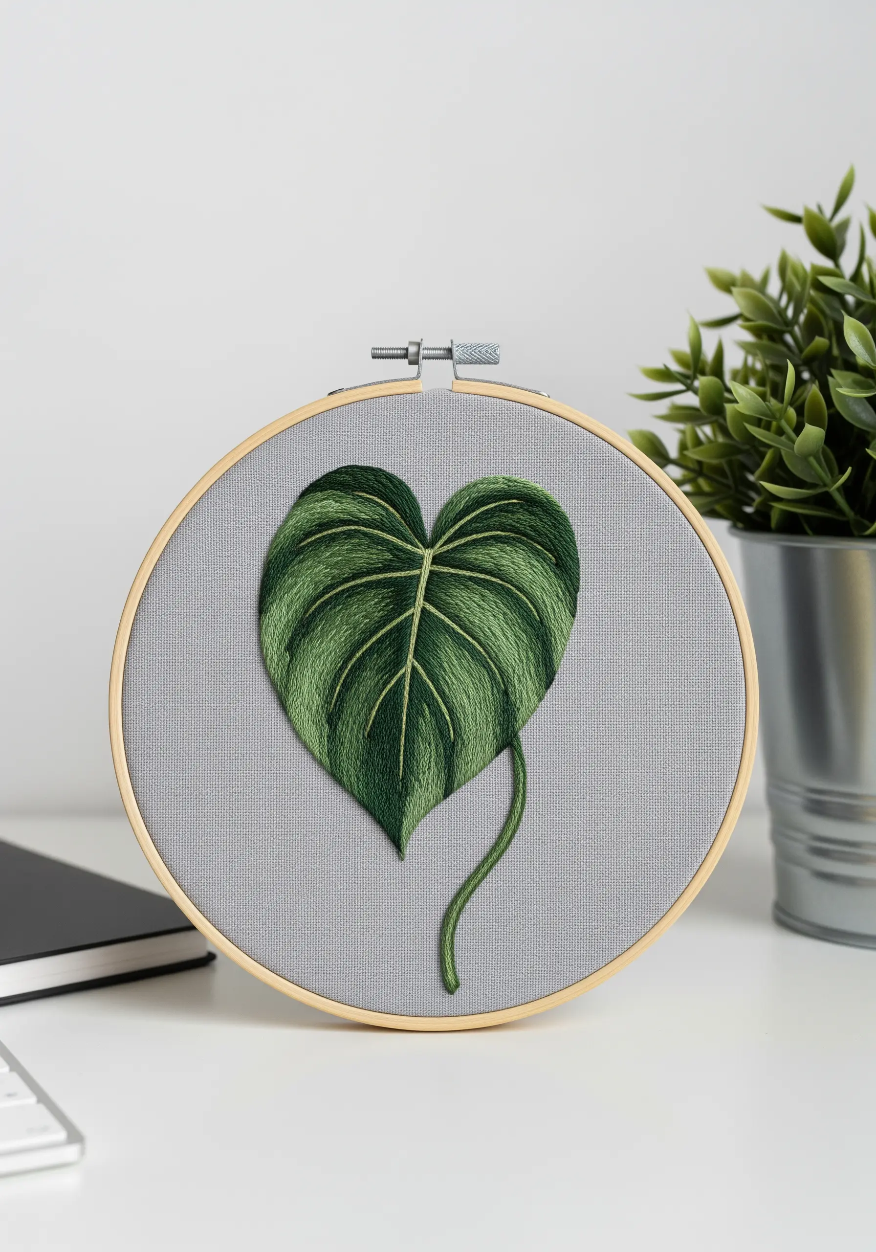 A perfectly shaded heart-shaped philodendron leaf on grey fabric, showing smooth gradients.