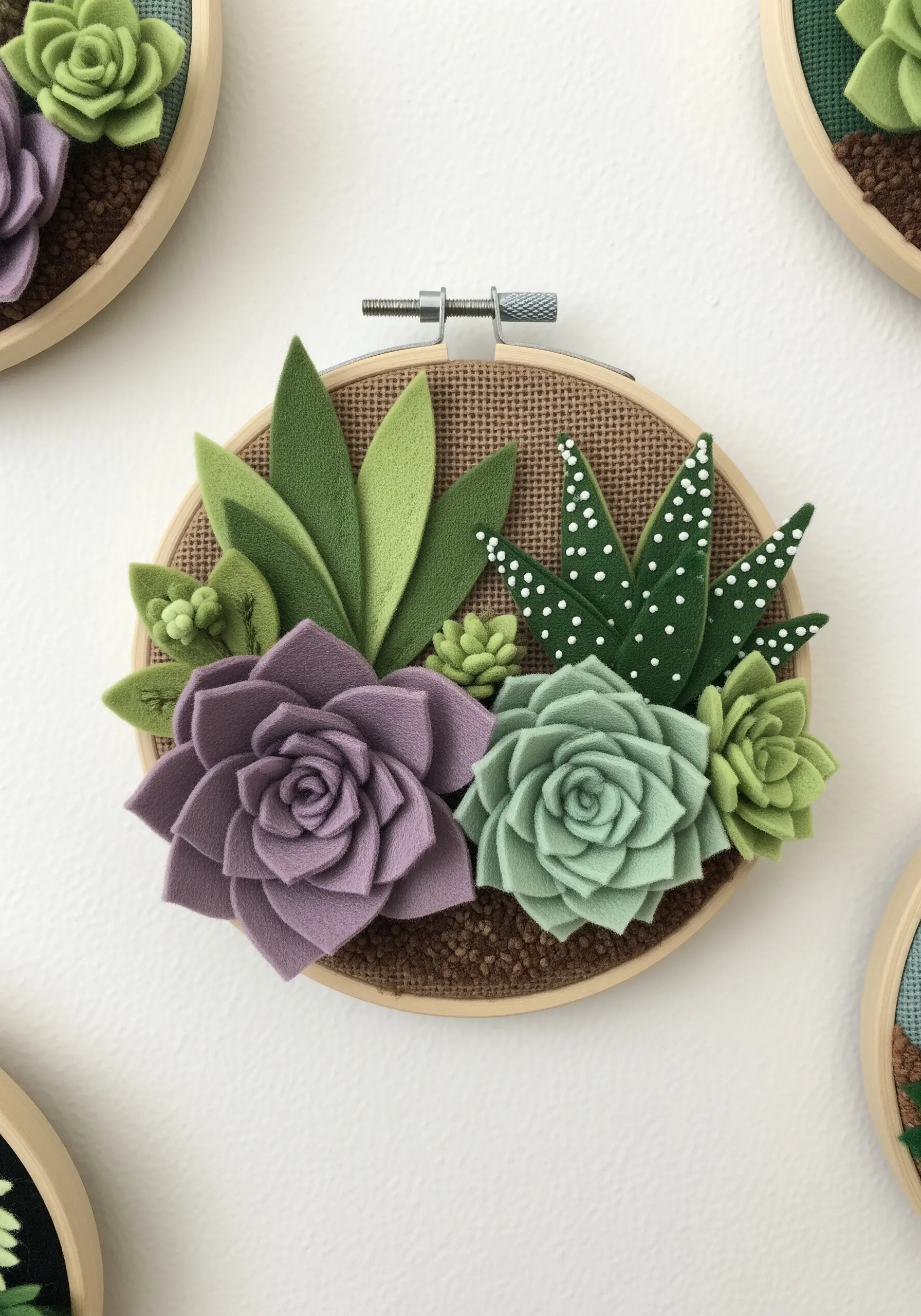 3D felt succulents and cacti arranged in a wooden embroidery hoop.