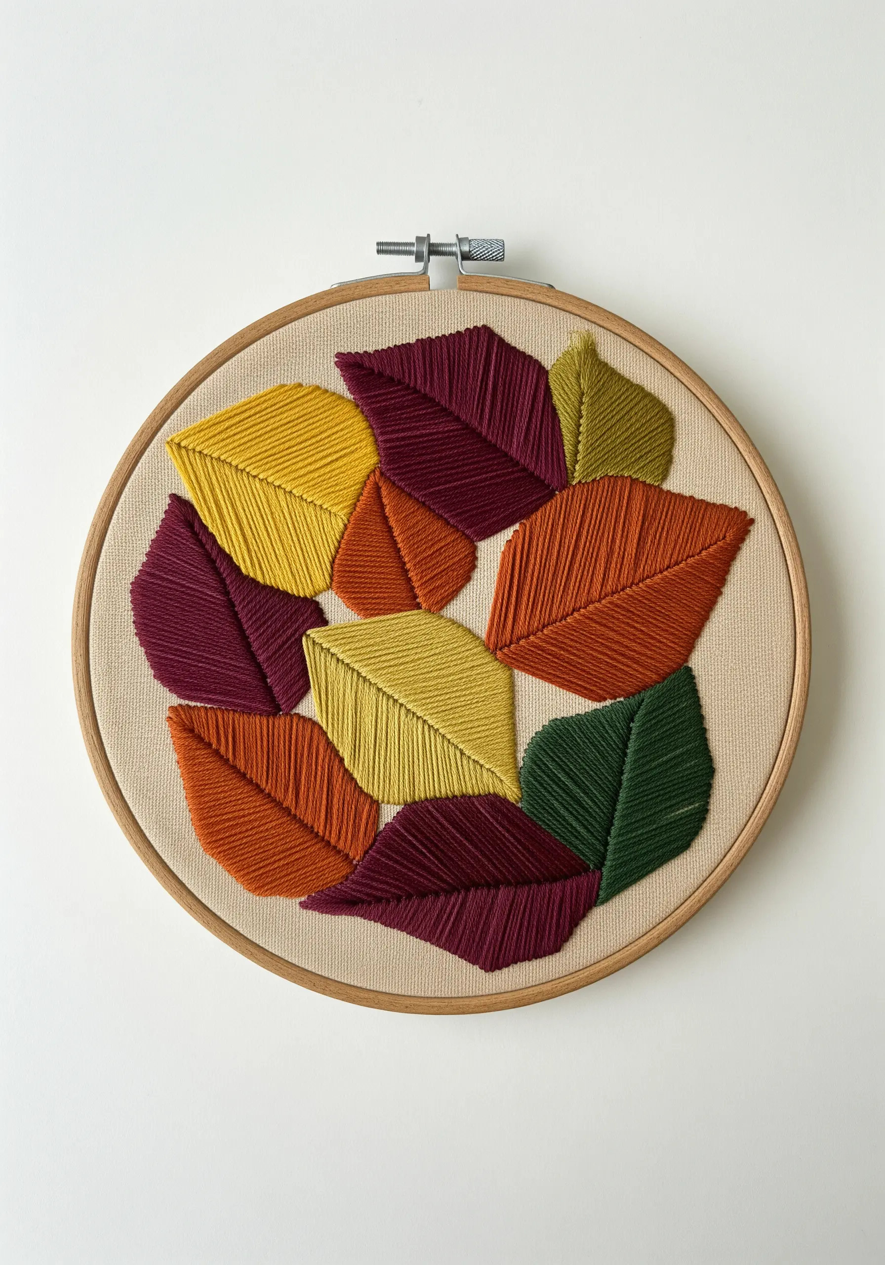 A collage of overlapping, satin-stitched leaves in autumn colors like red, yellow, and green.