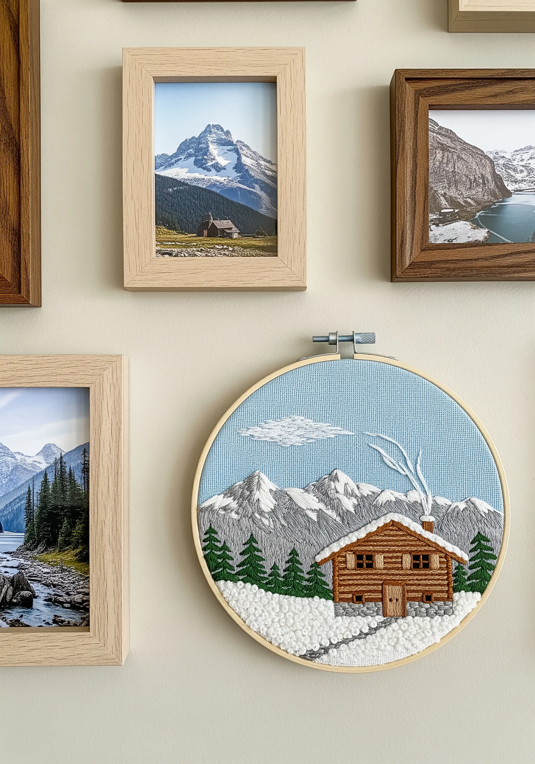 Embroidered winter scene of a log cabin with French knot snow and thread-painted mountains.