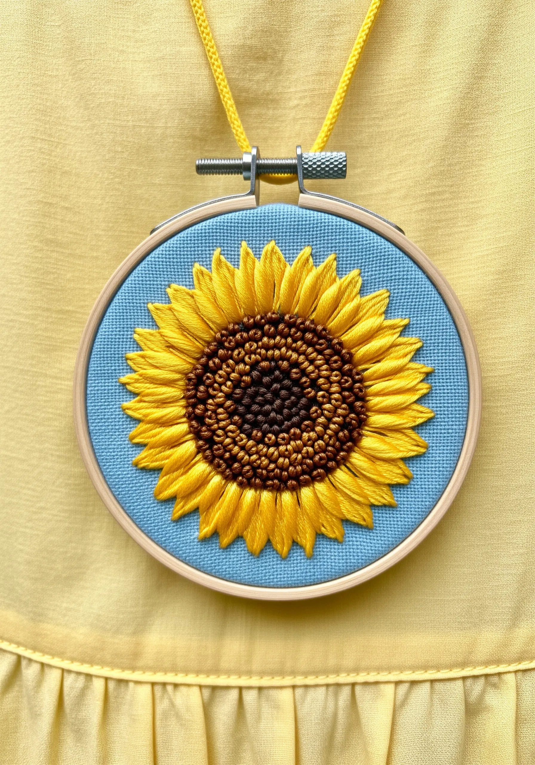 A detailed sunflower embroidery with a textured French knot center and satin stitch petals.