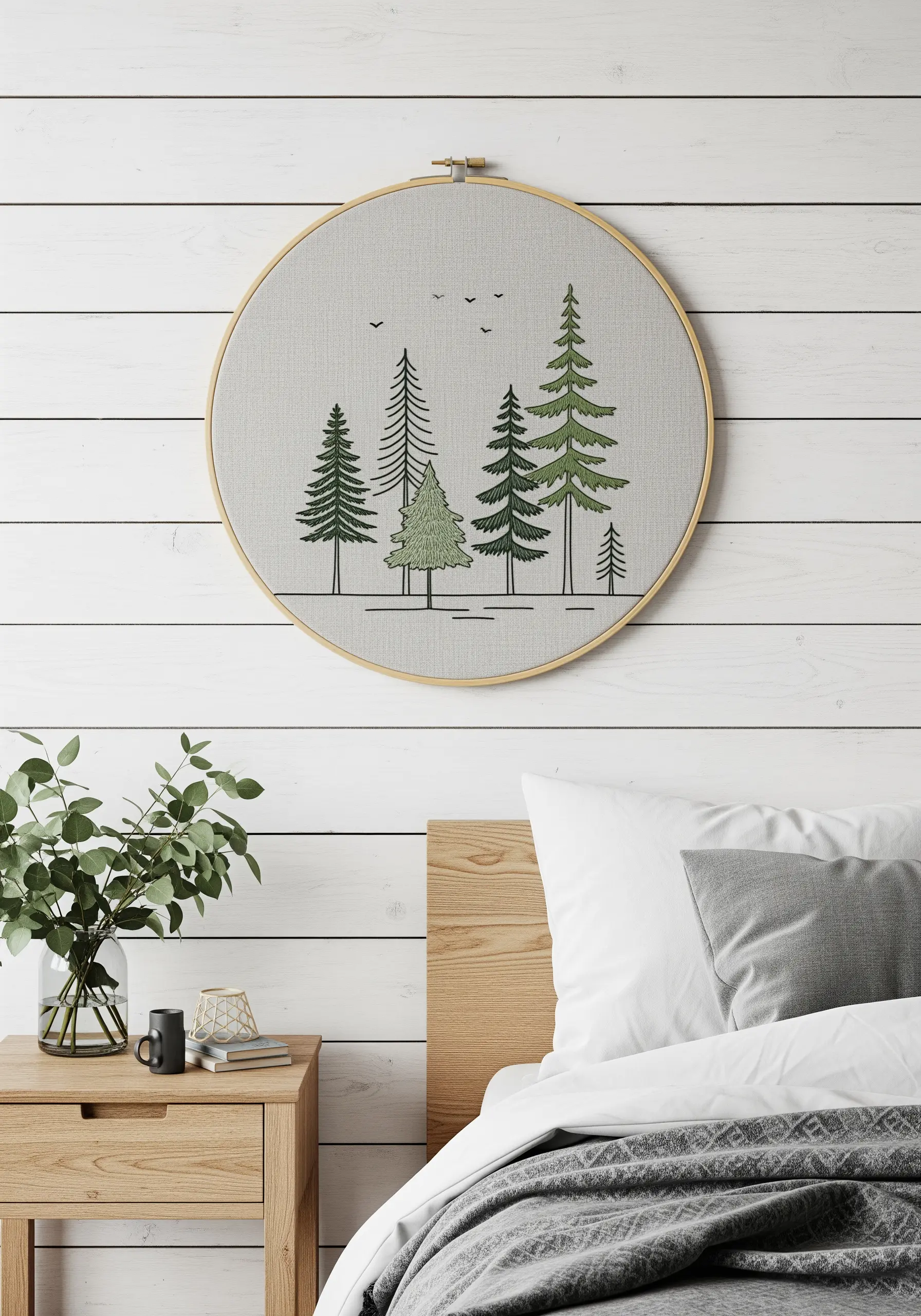 A minimalist forest scene with pine trees embroidered using various green threads and textures.