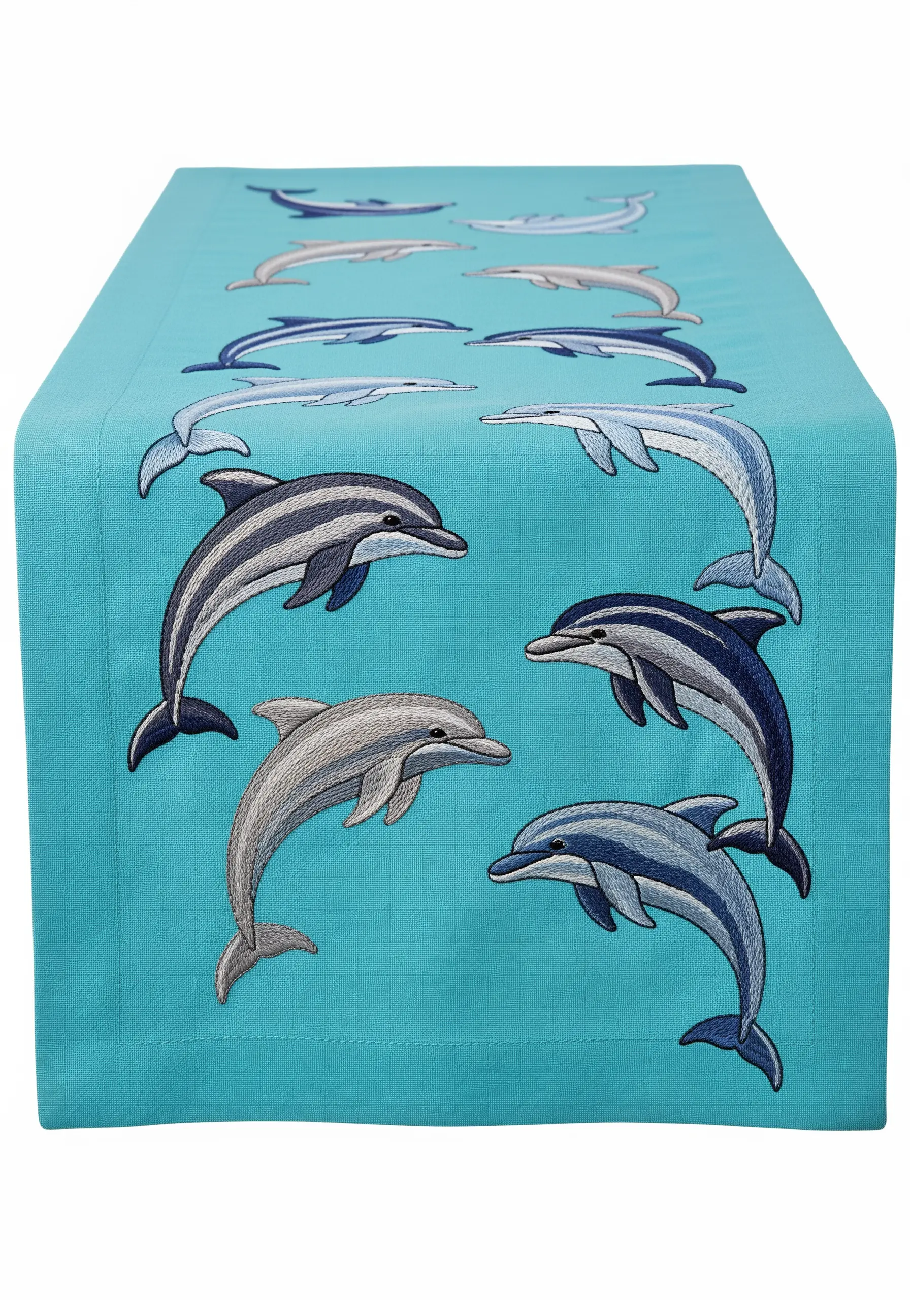 A pattern of embroidered dolphins swimming in groups on a turquoise table runner.