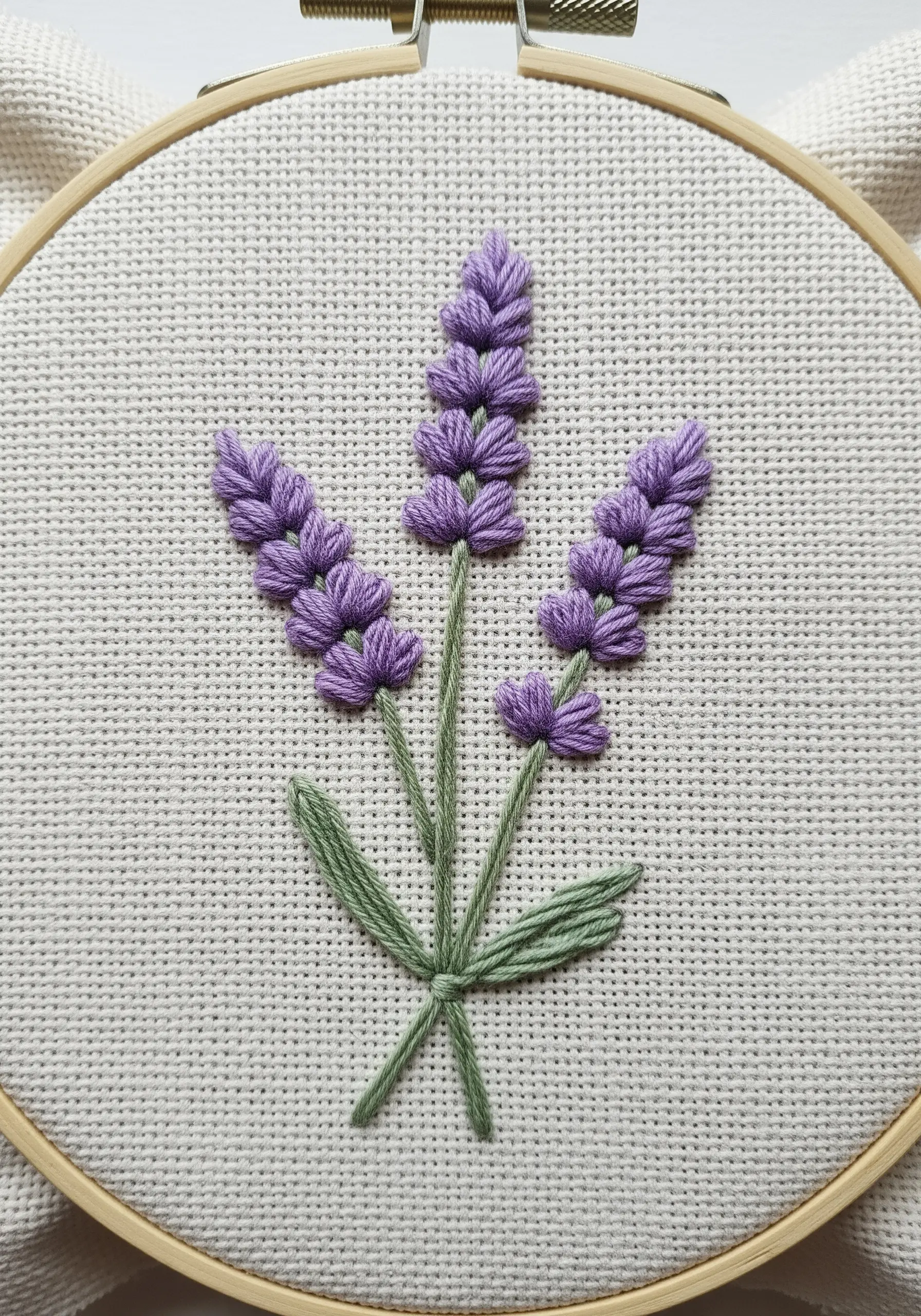 Embroidered lavender sprigs with textured purple buds and sleek green stems.