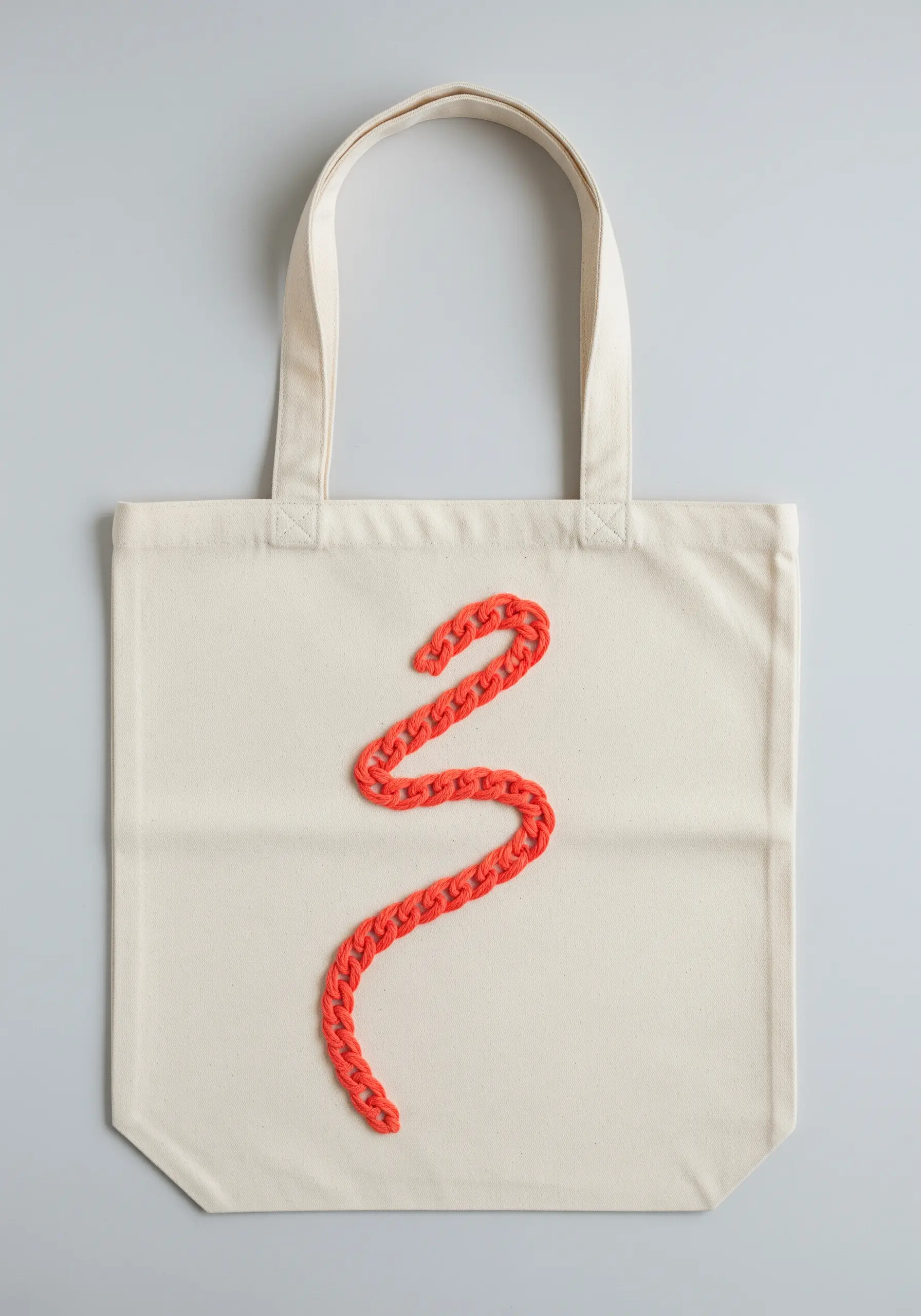 A thick, winding red line embroidered using a raised chain stitch technique.