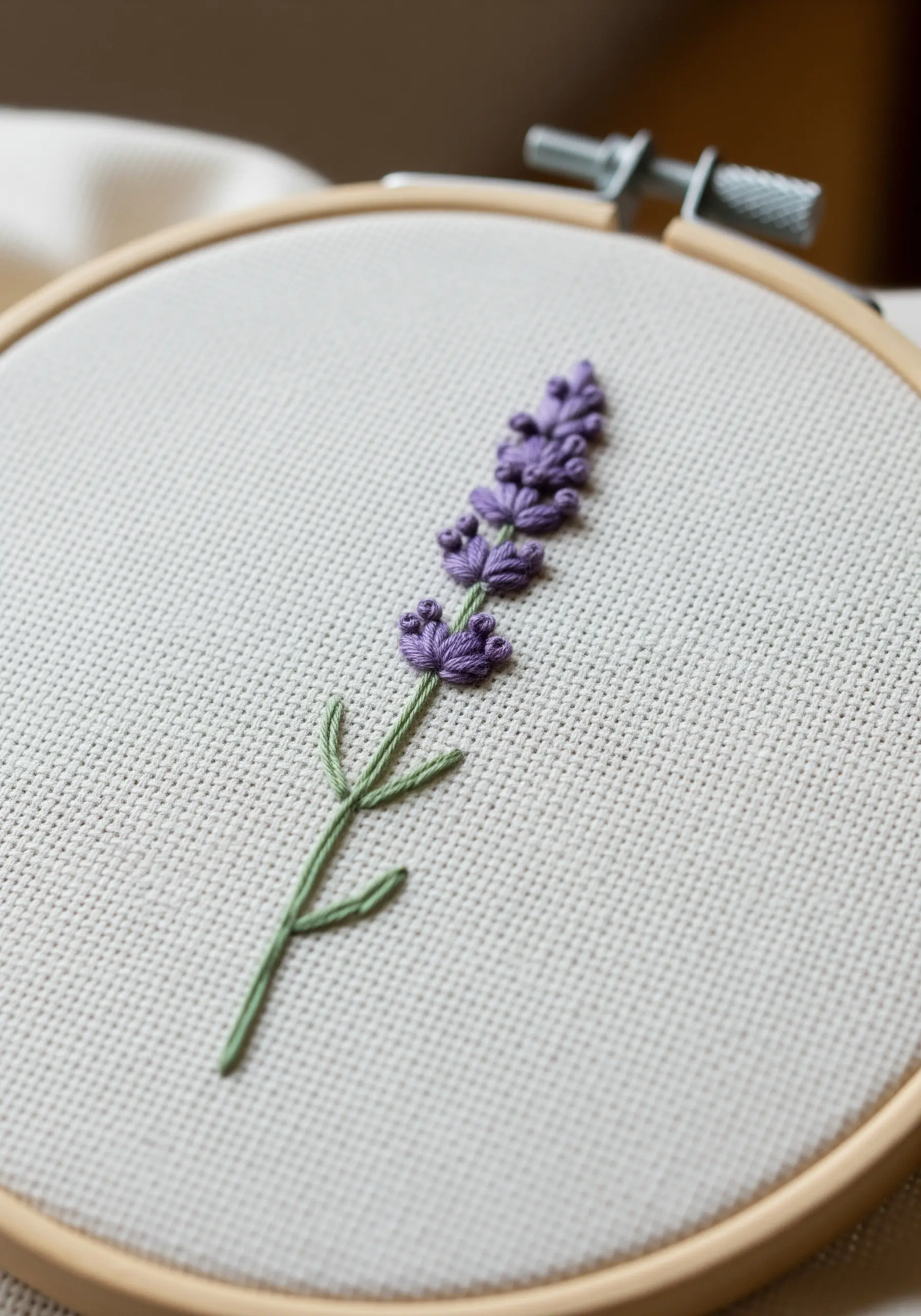 Lavender sprig with purple woven wheel stitch buds and a green stem stitch.