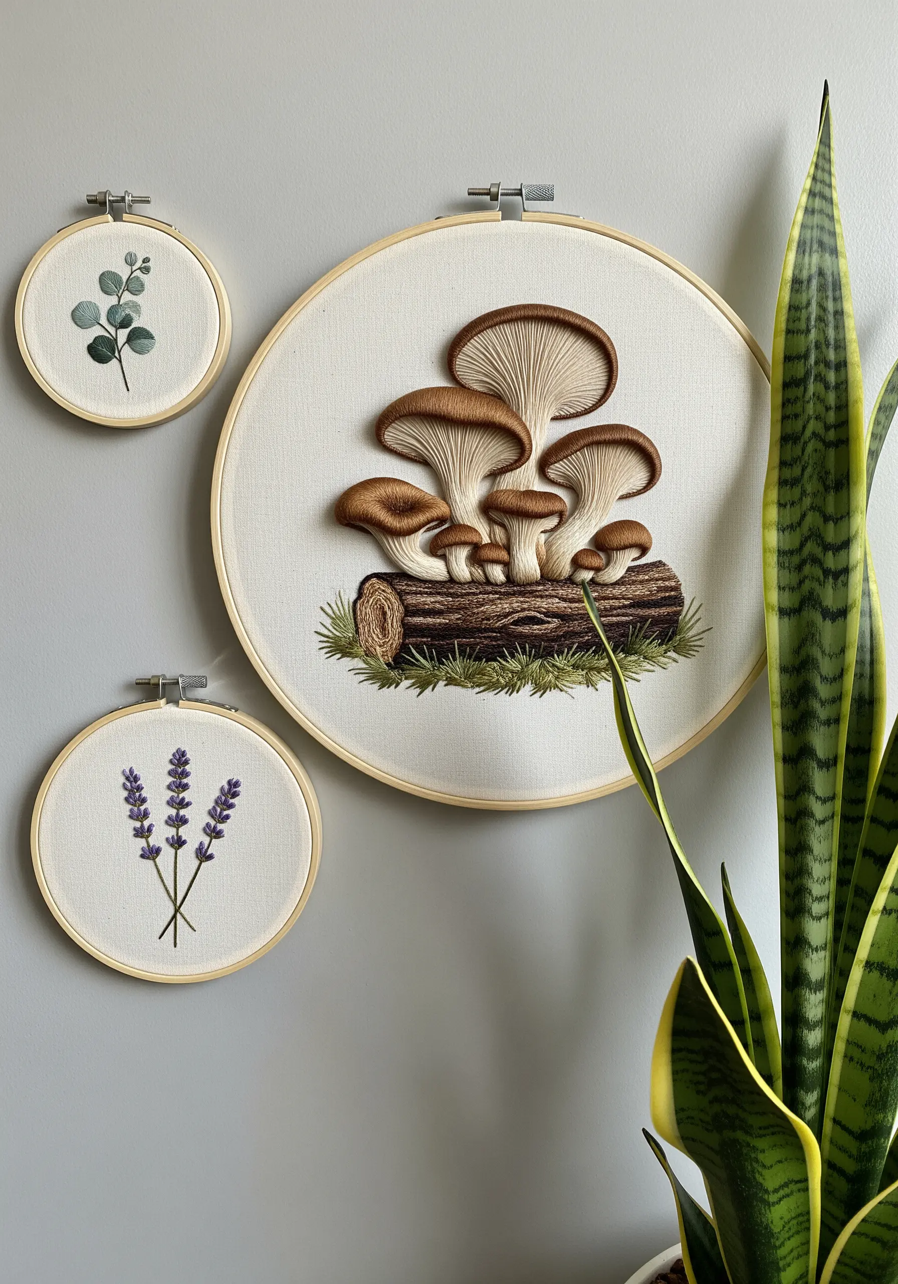 Embroidery hoop art showing hyper-realistic mushrooms on a log.