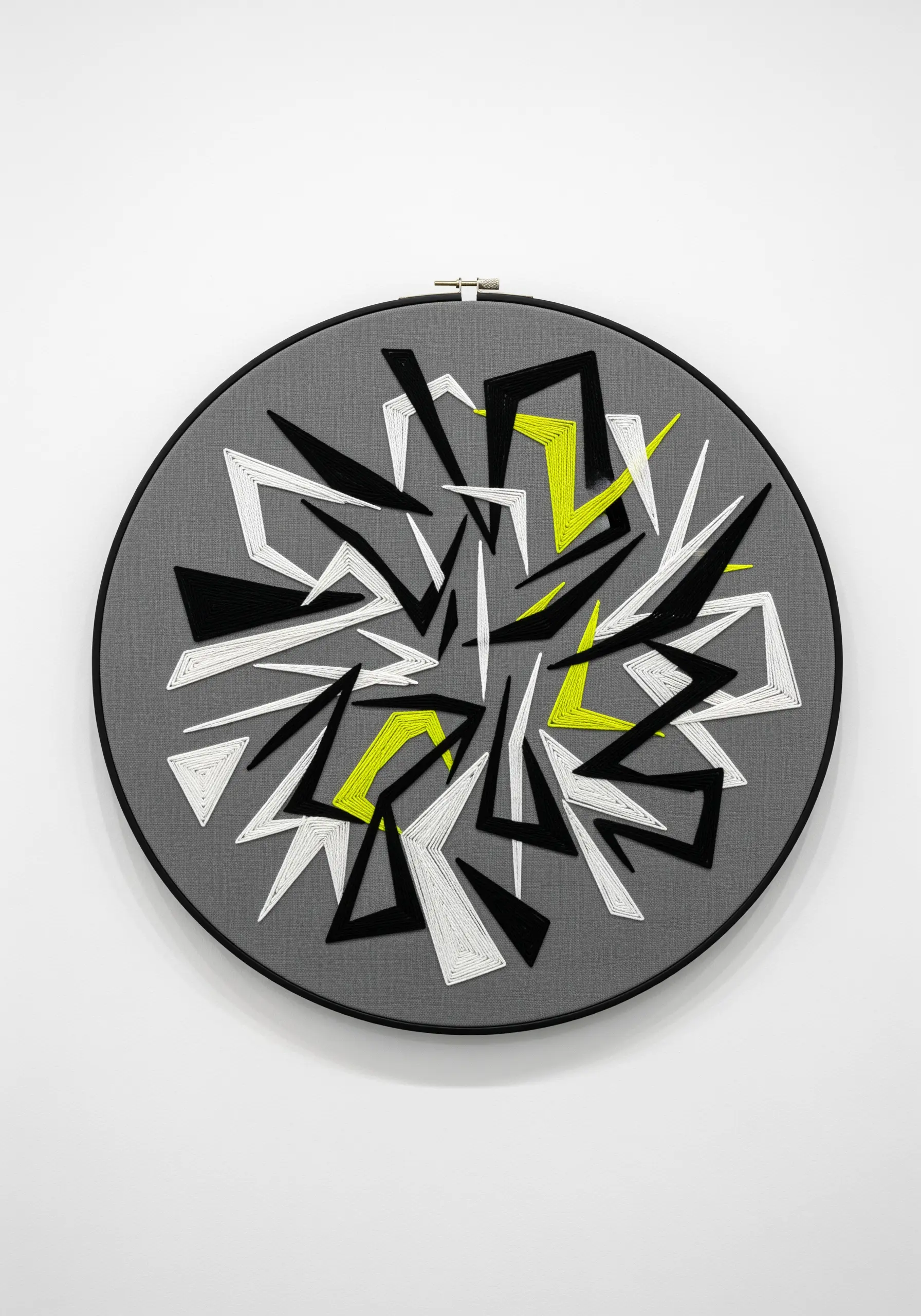 An abstract explosion of black, white, and lime green geometric shards on gray fabric.