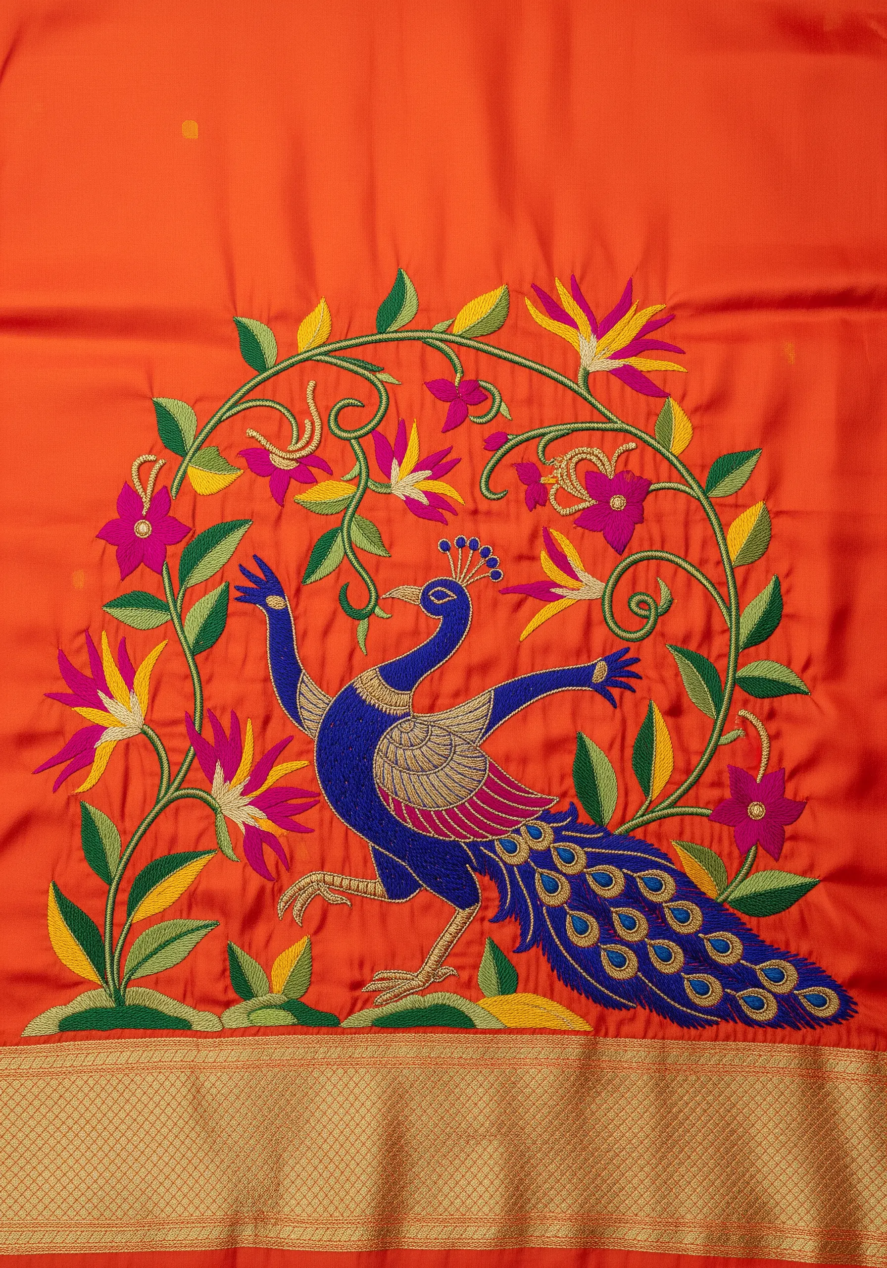 A stylized, dancing peacock in a folk-art style on bright orange fabric.