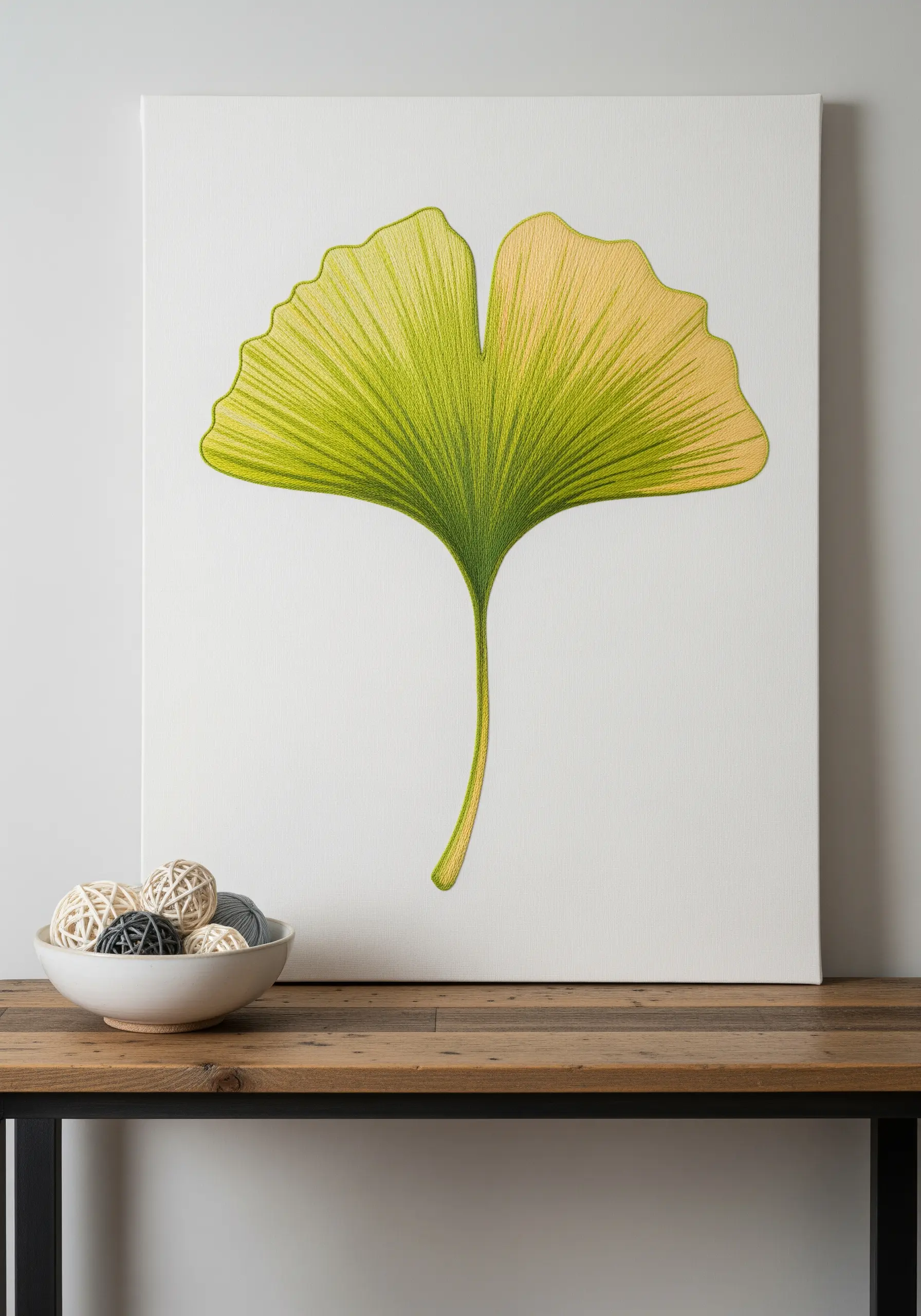 An embroidered ginkgo leaf on a white canvas, with a smooth gradient from green to yellow.