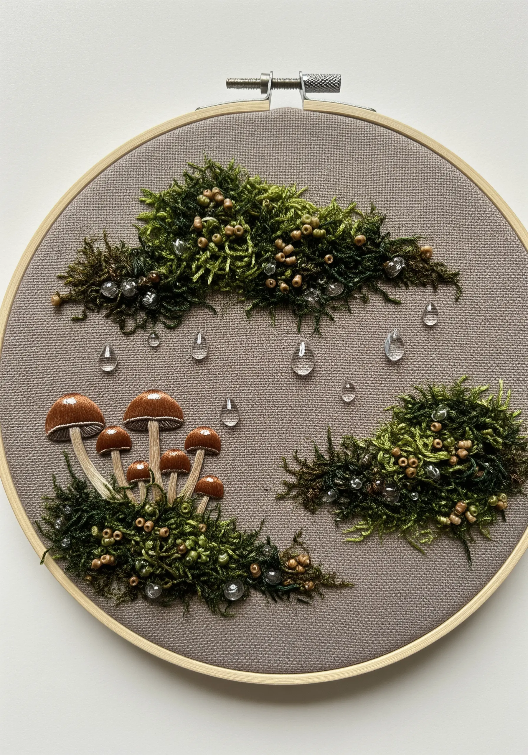 Embroidered moss and mushrooms with clear, teardrop-shaped beads representing raindrops.