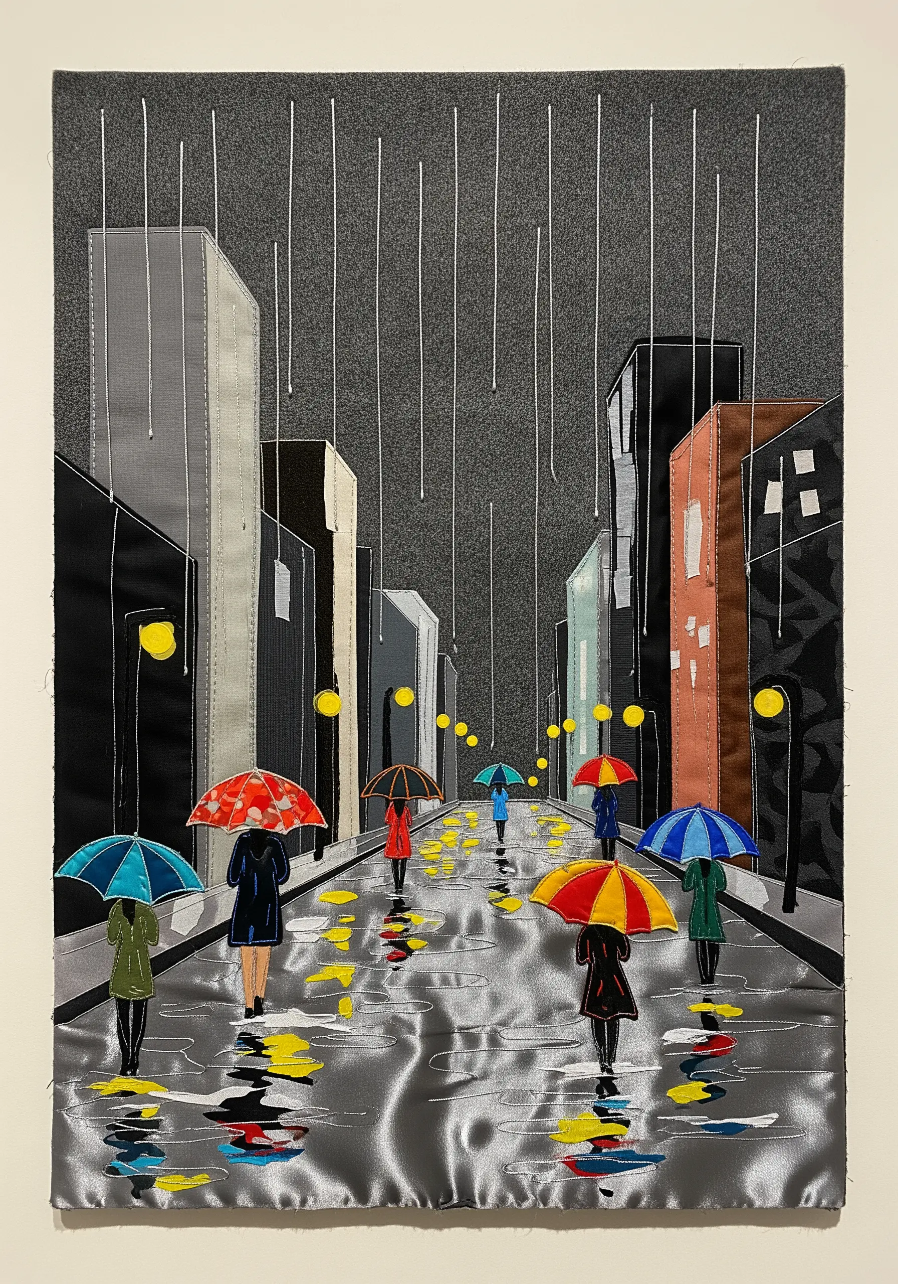 Fabric collage of a rainy city street using gray satin to simulate wet pavement