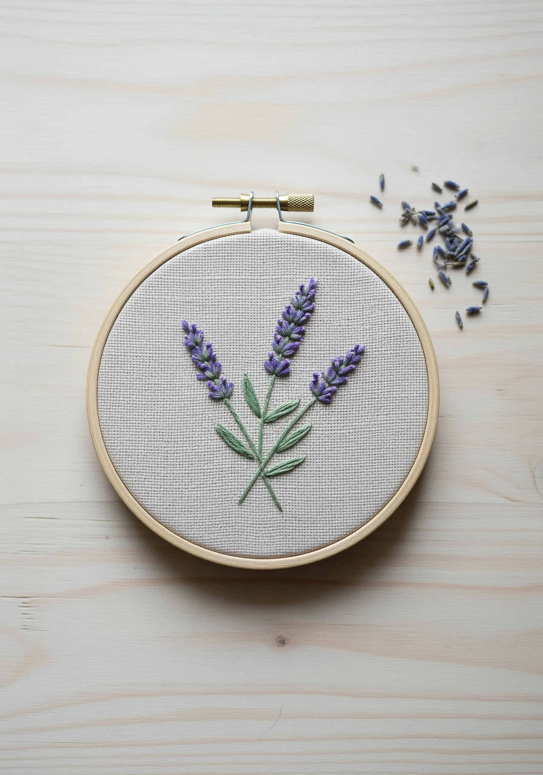 Hand-embroidered lavender sprigs in a wooden hoop, featuring textured French knots.