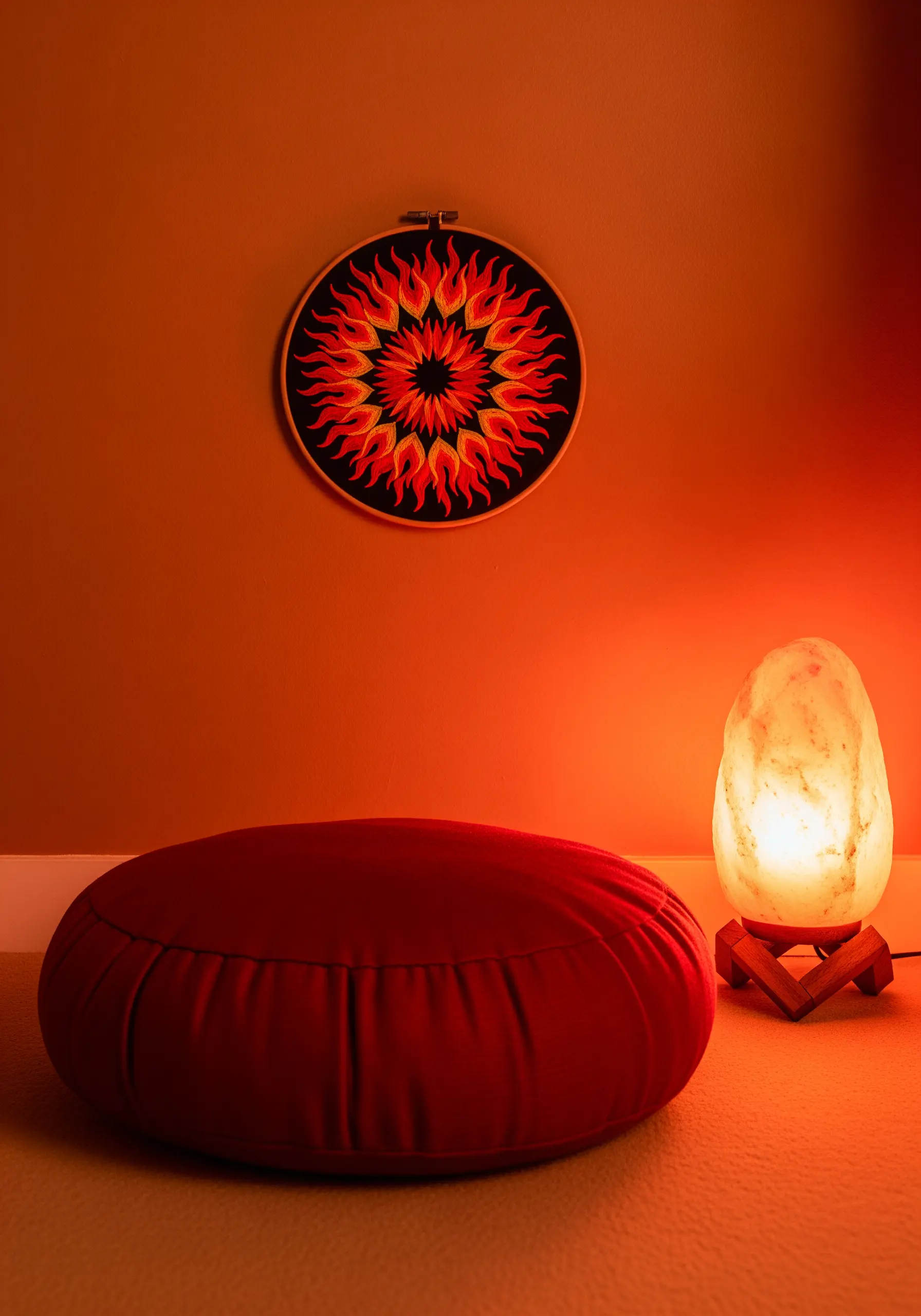 A vibrant mandala of red, orange, and yellow flames embroidered on black fabric.