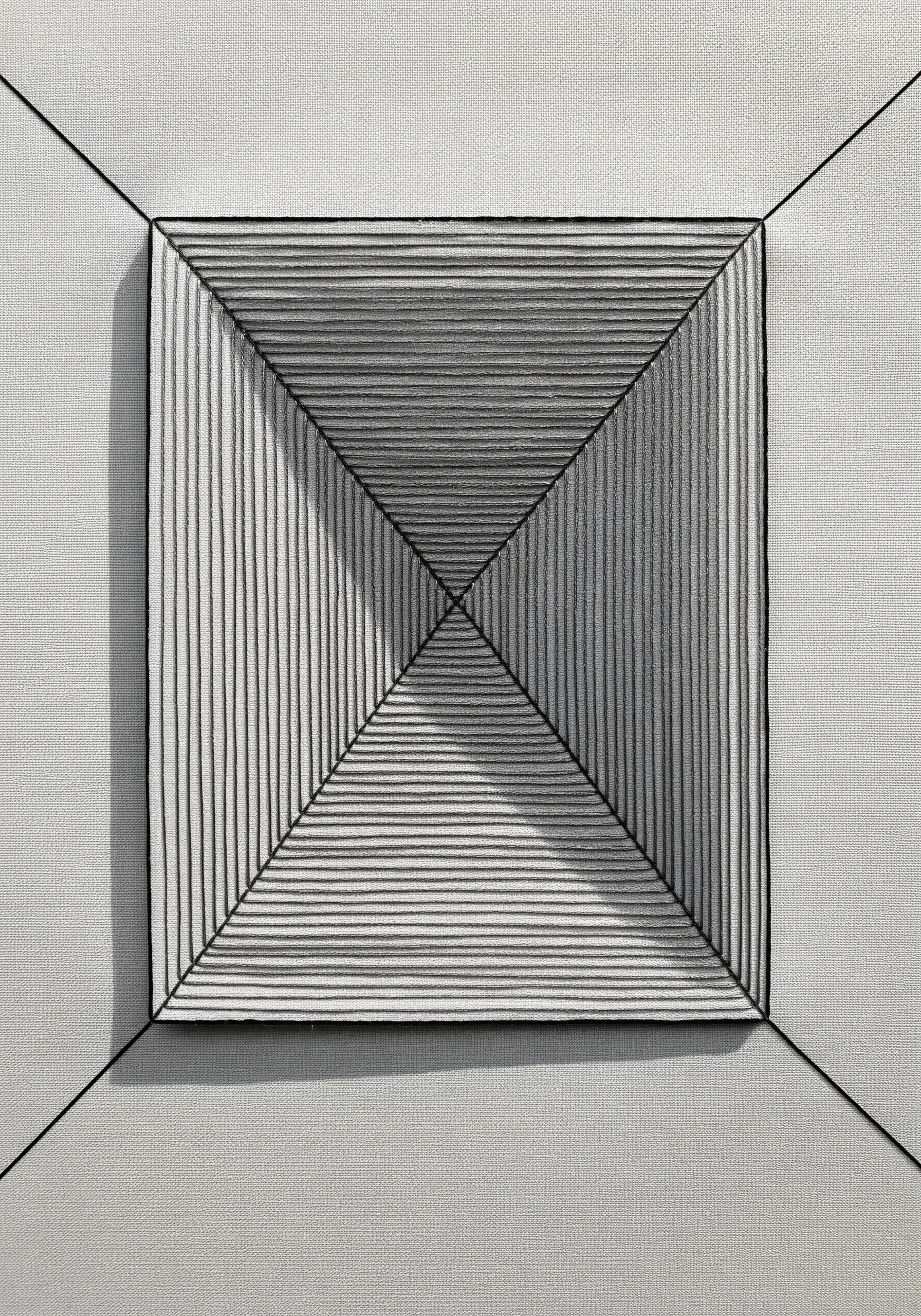 An embroidered square with black straight stitches creating an illusion of a receding pyramid.