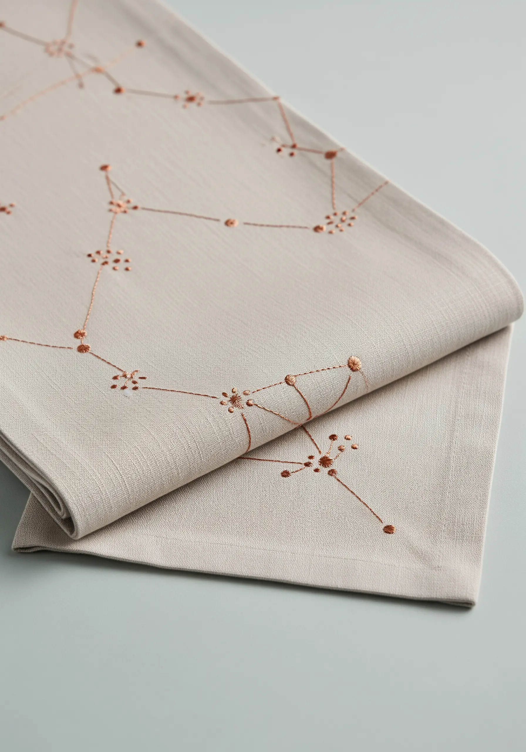 Delicate copper metallic thread forming geometric constellations with French knot clusters.