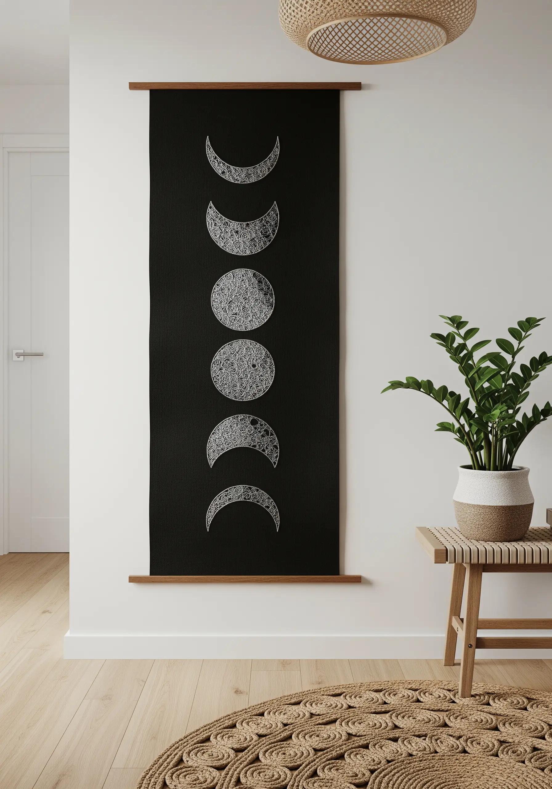 Black wall hanging with embroidered moon phases filled with intricate white patterns.