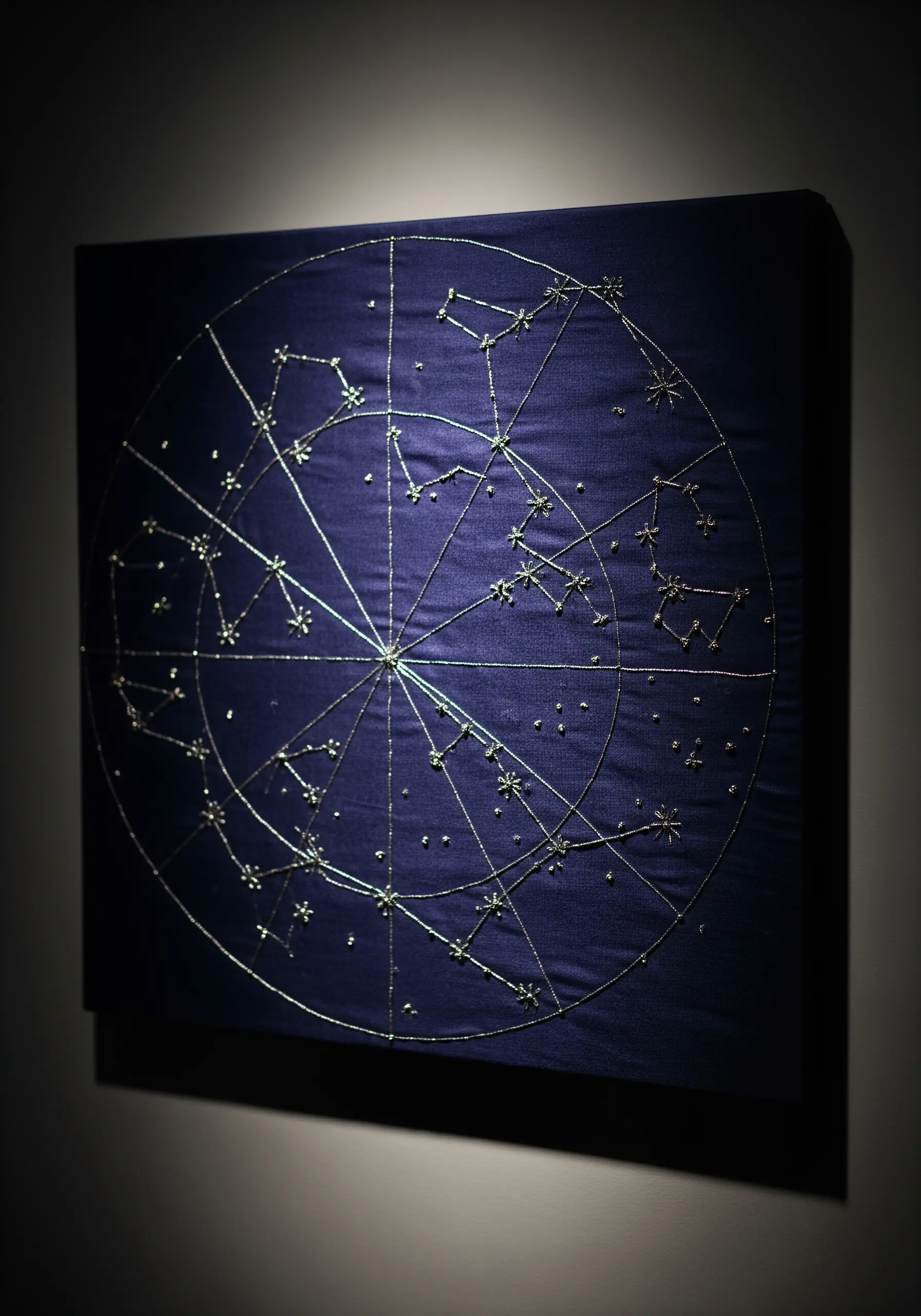 A square canvas embroidered with a silver metallic thread constellation map on a dark blue background.