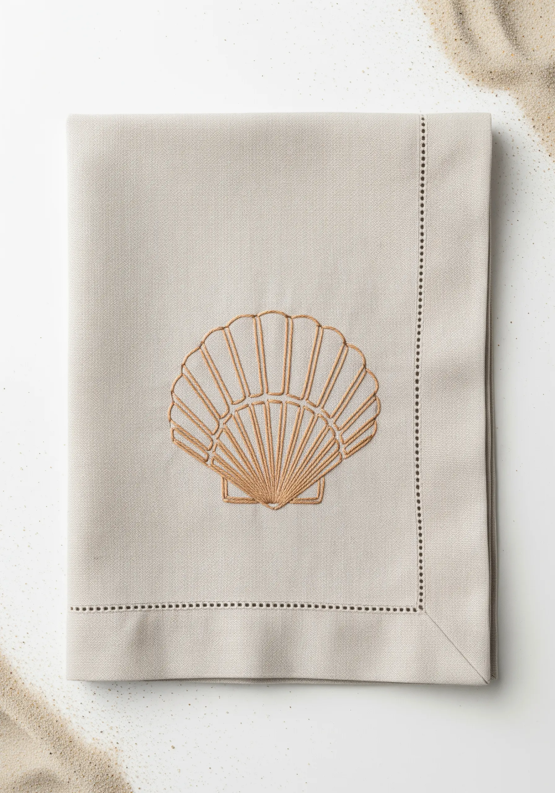 A fan-shaped seashell embroidered in two tones of beige on a linen napkin.