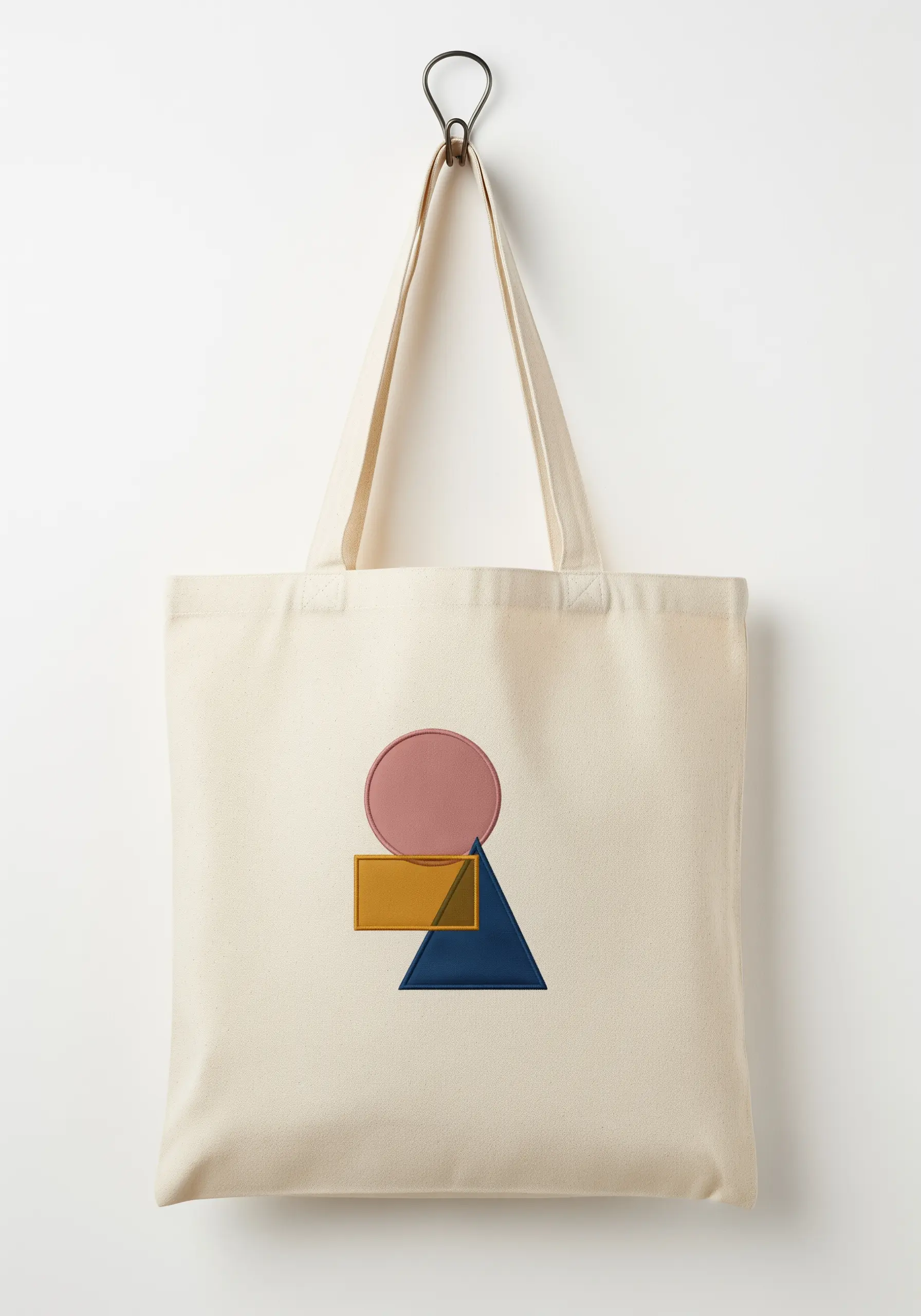 Modern tote bag with color-blocked geometric shapes—a circle, rectangle, and triangle.
