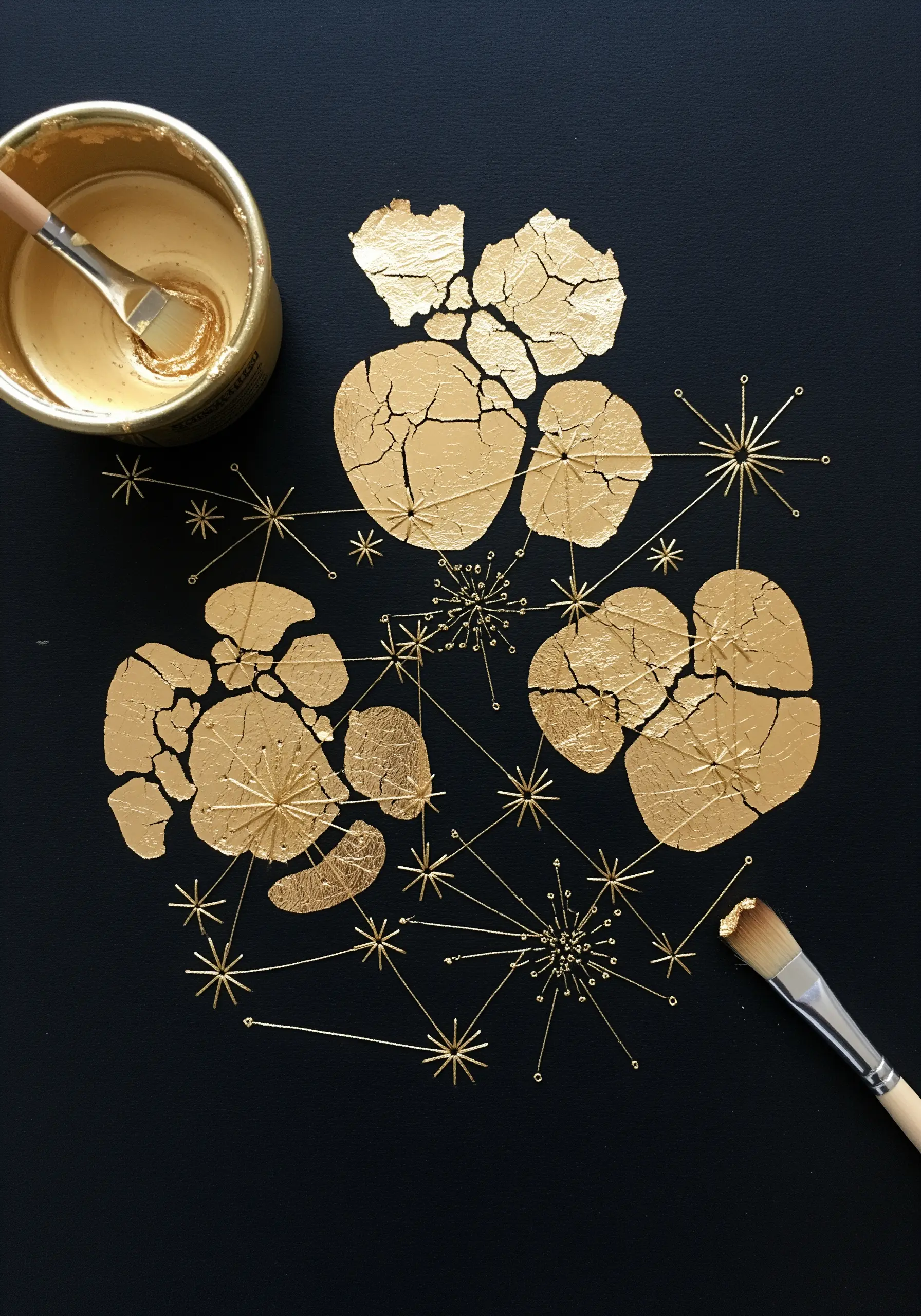 Cracked gold leaf shapes on black paper with stitched gold starbursts.