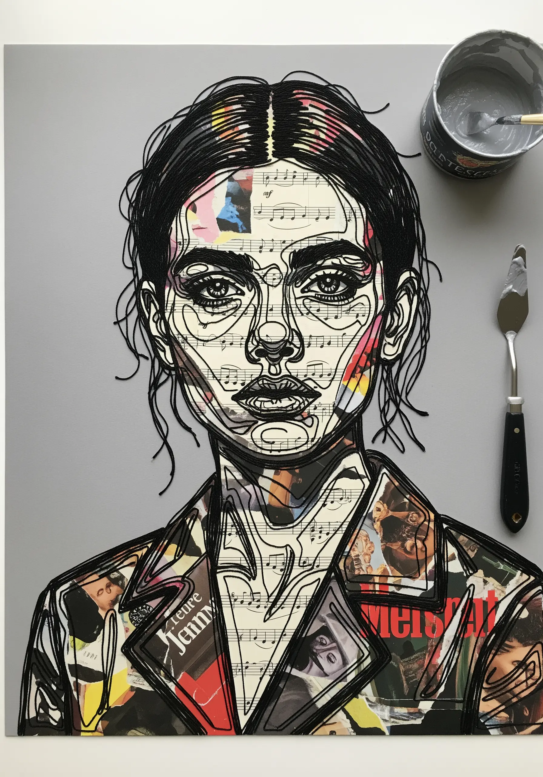 A portrait made from paper collage and black embroidered line art on a gray background.