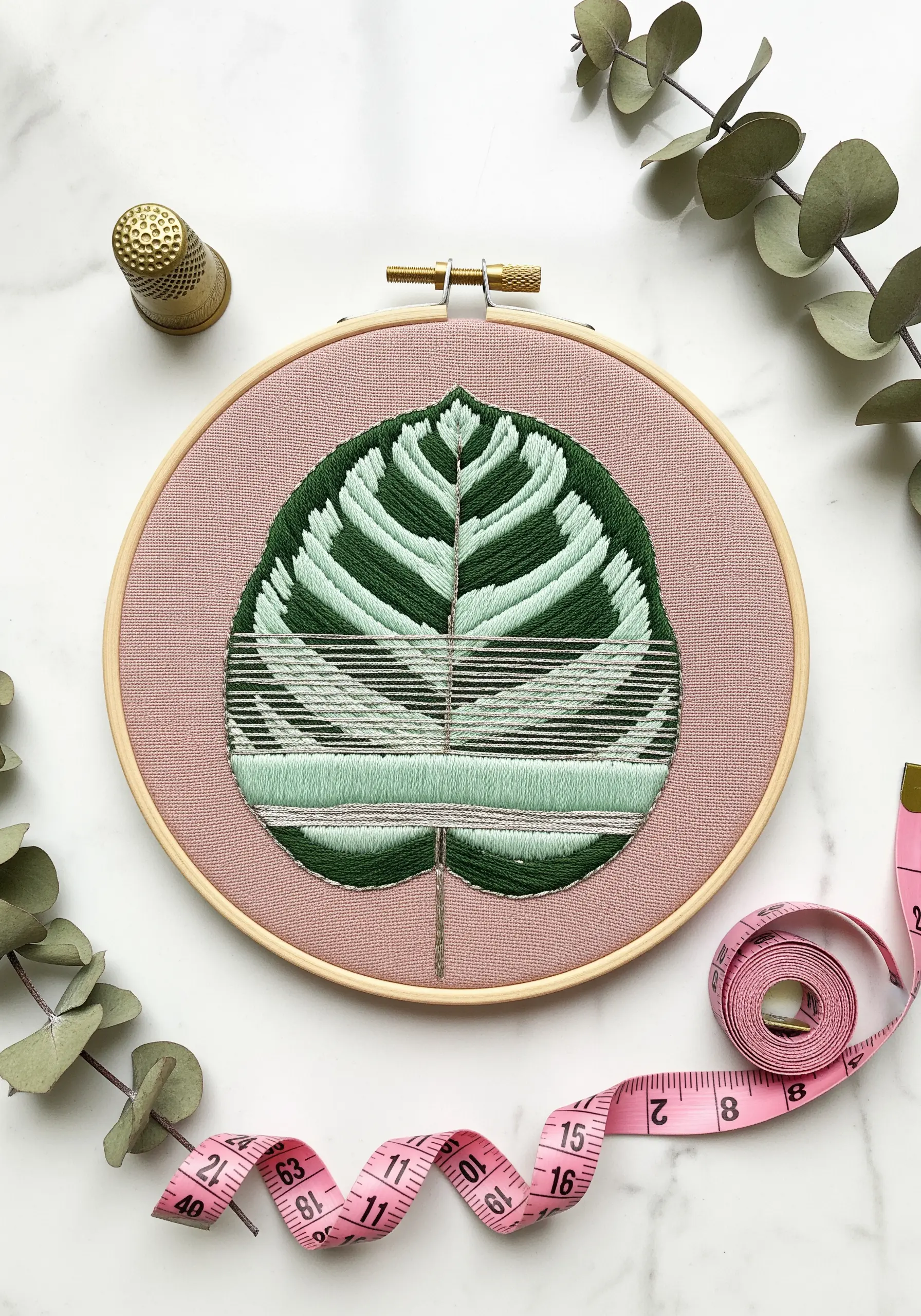 A single Calathea leaf embroidered with satin stitch and spaced straight stitches.