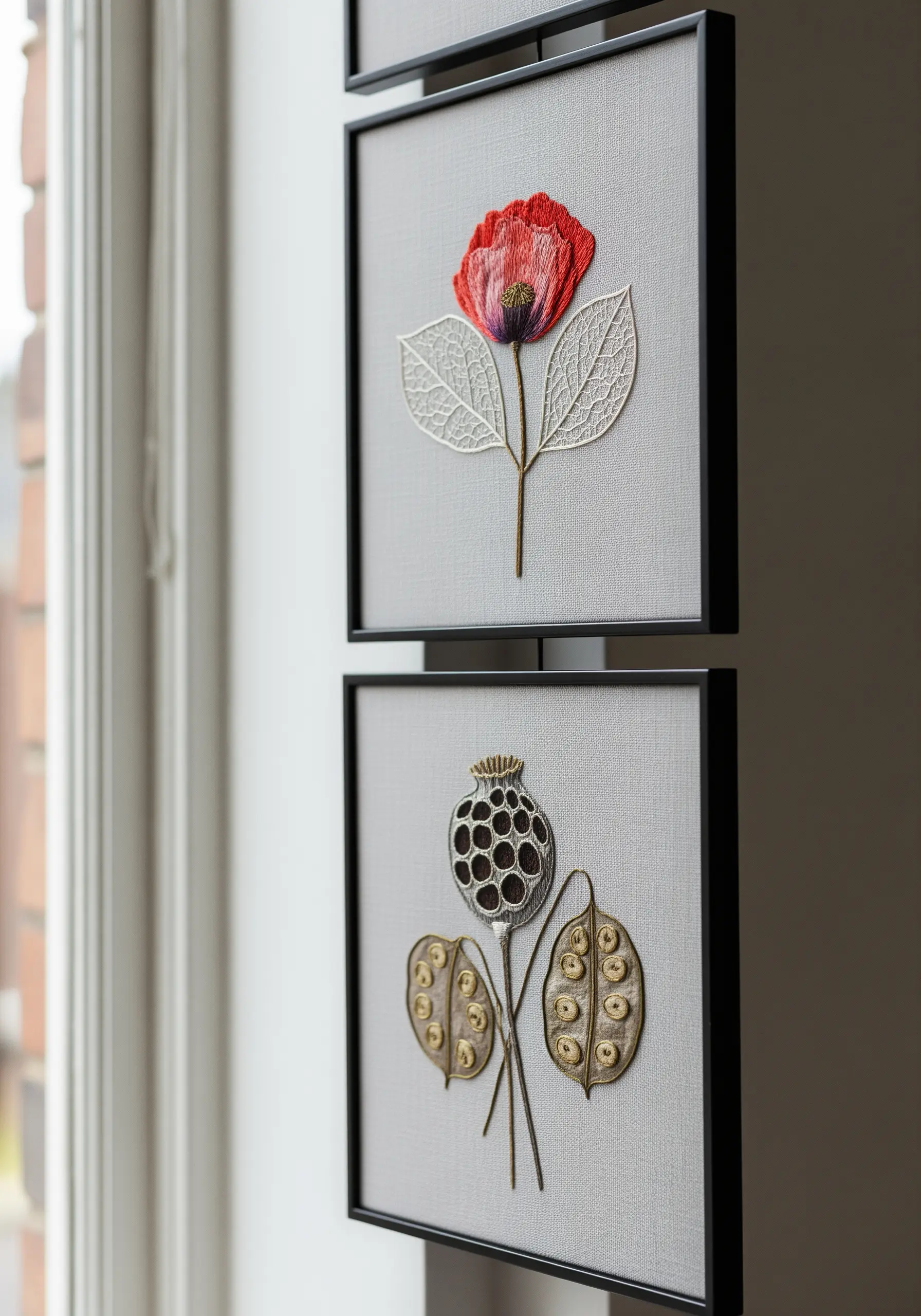 Two framed embroidery pieces: one of a red poppy, the other of a dried seed pod.