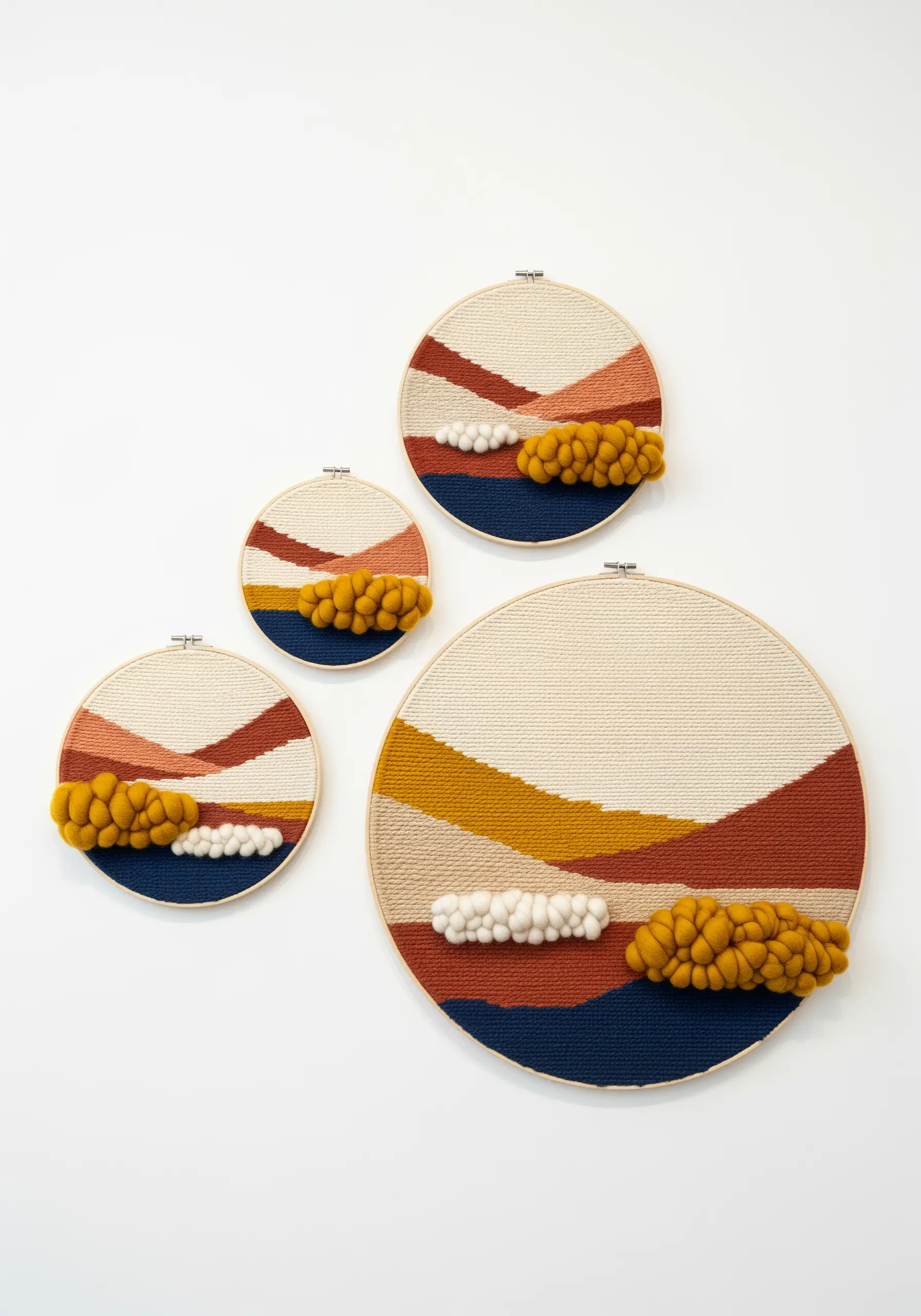 A set of four woven hoop art pieces depicting abstract landscapes in earthy tones.