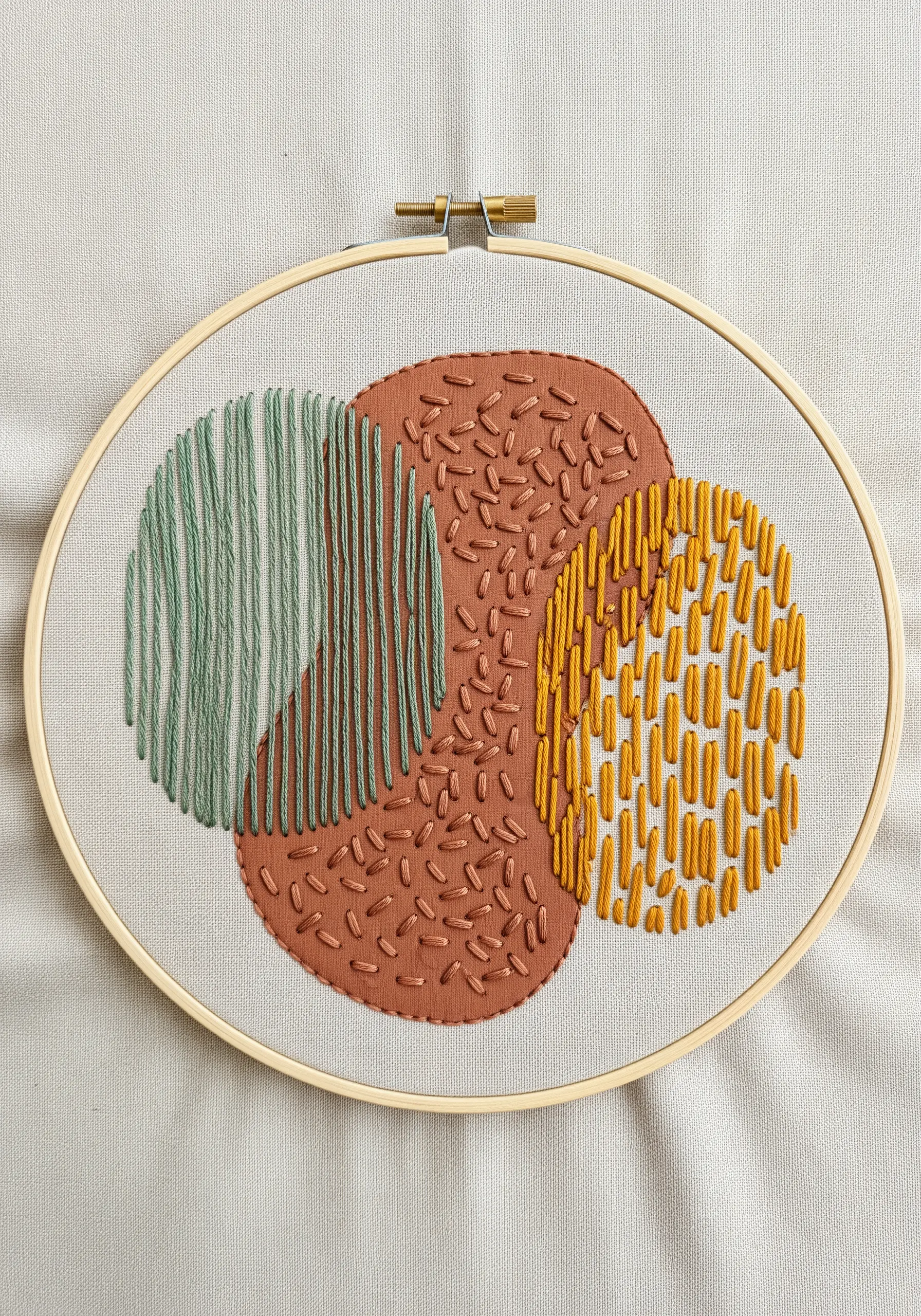 Abstract hoop art with three overlapping circles filled with different stitch textures.