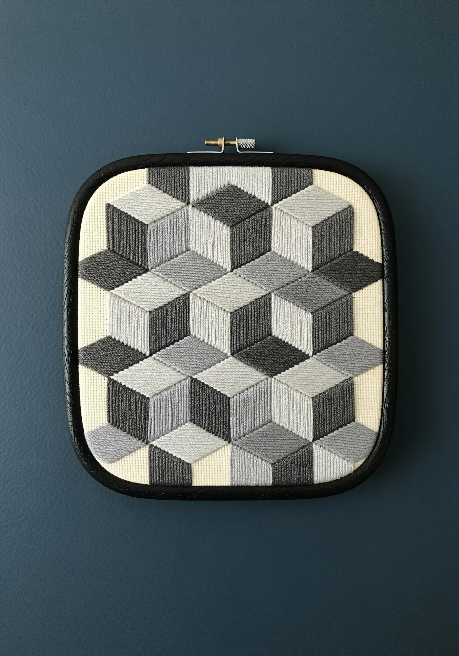 A 3D tumbling blocks pattern stitched in shades of gray, creating an isometric cube illusion.