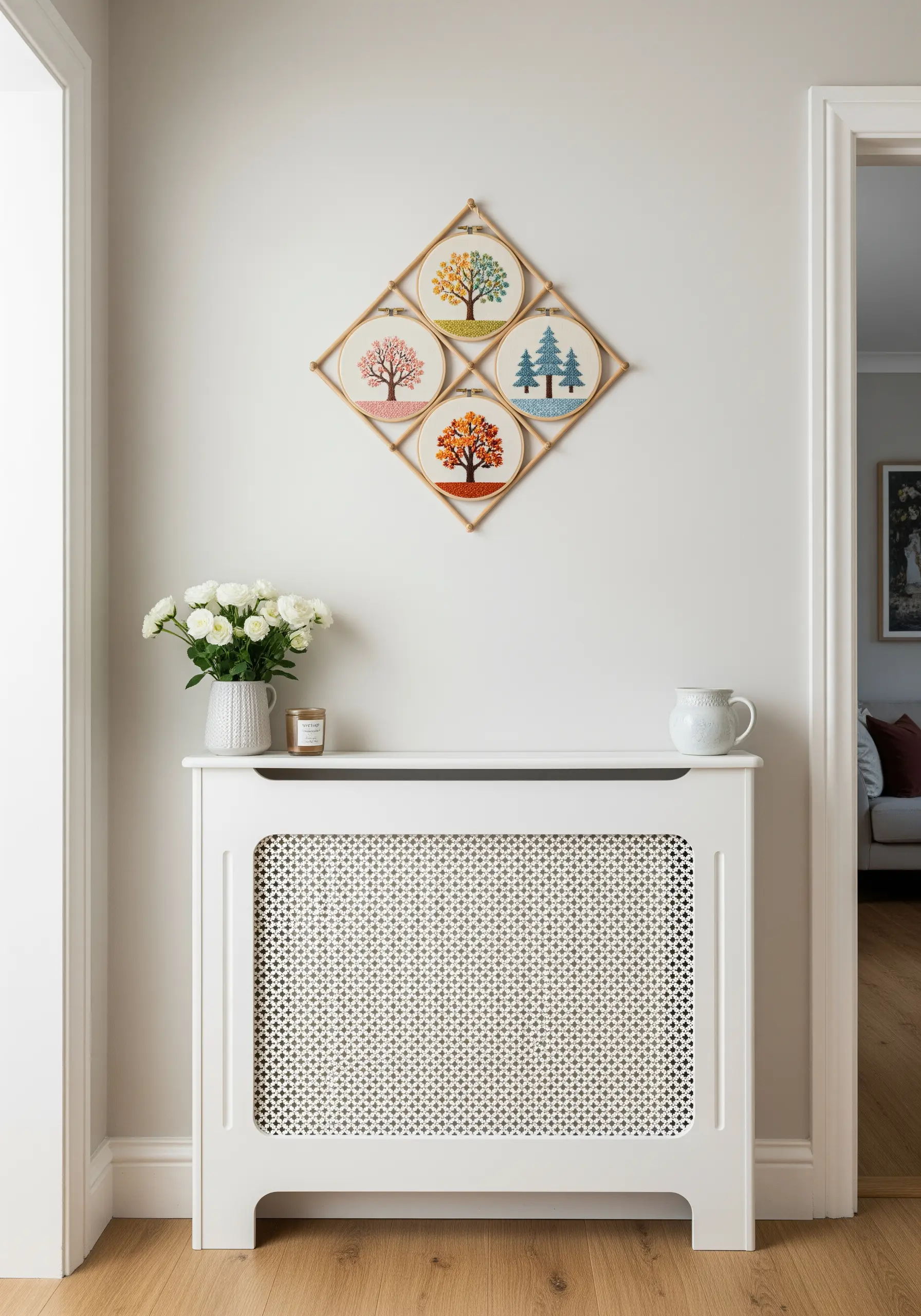 Four embroidery hoops depicting trees in four seasons, arranged in a diamond shape with bamboo sticks