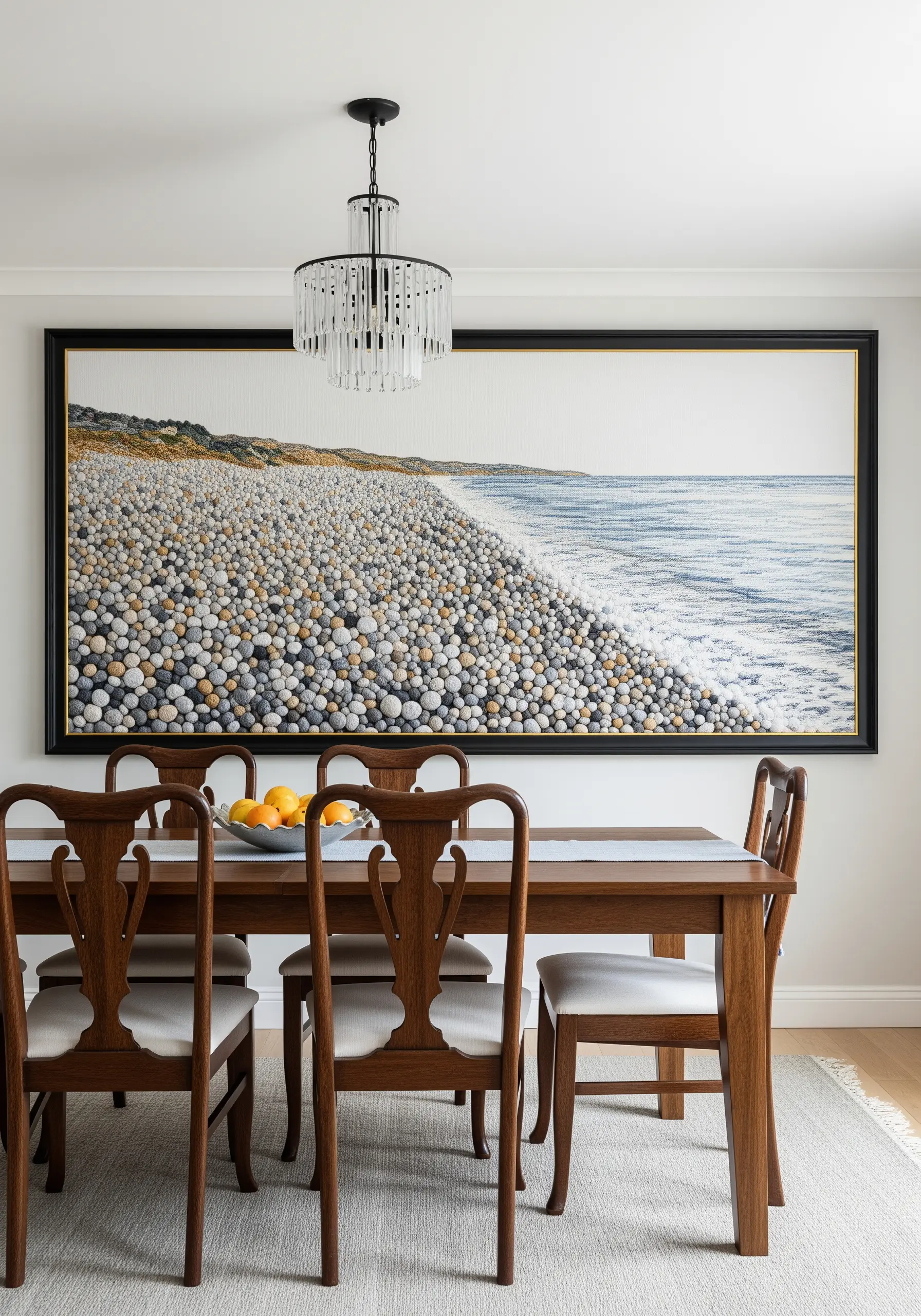 Large framed embroidery of a pebble beach and ocean waves, rich in texture.