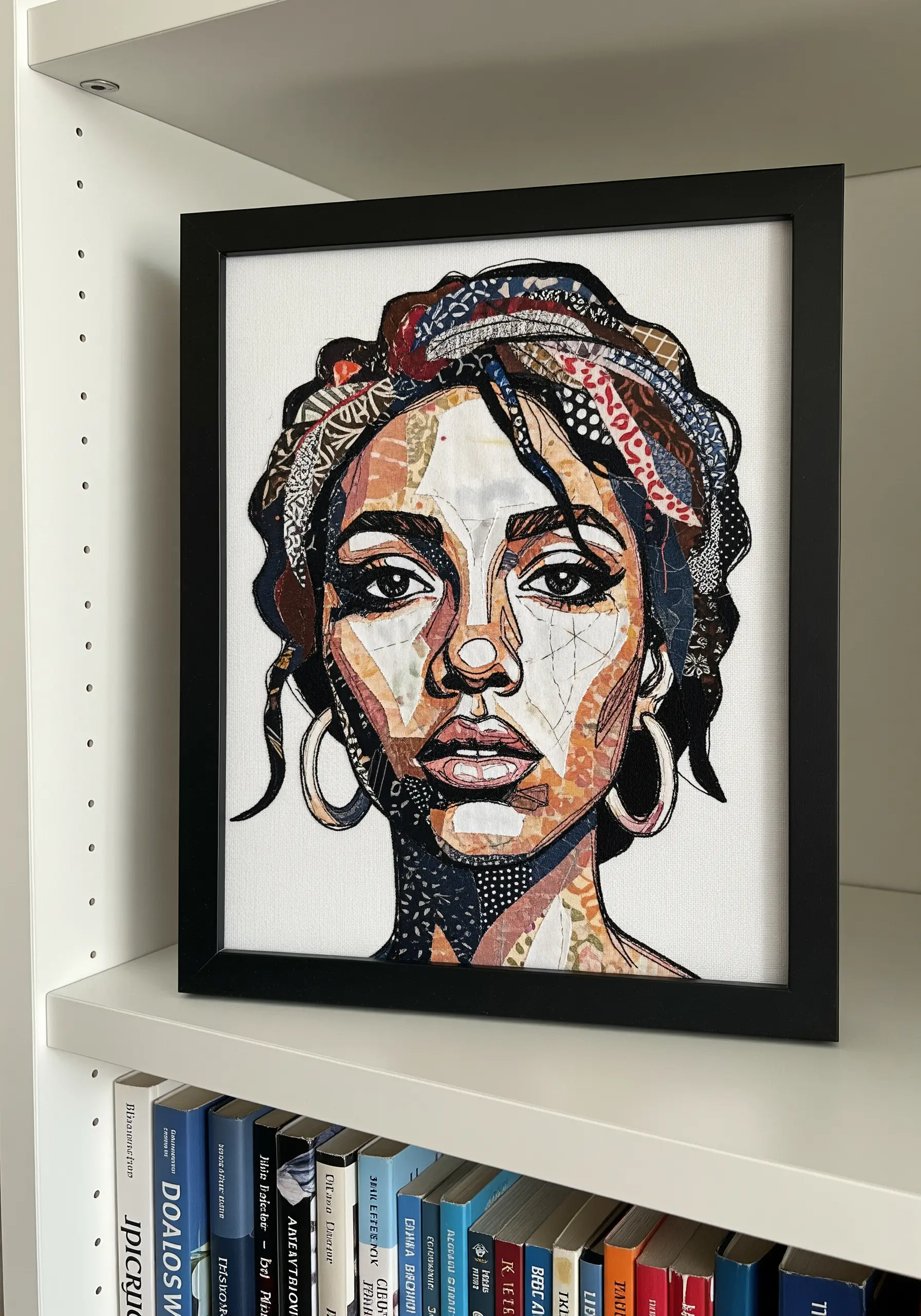 Framed portrait of a woman created from a collage of tiny, patterned fabric scraps.