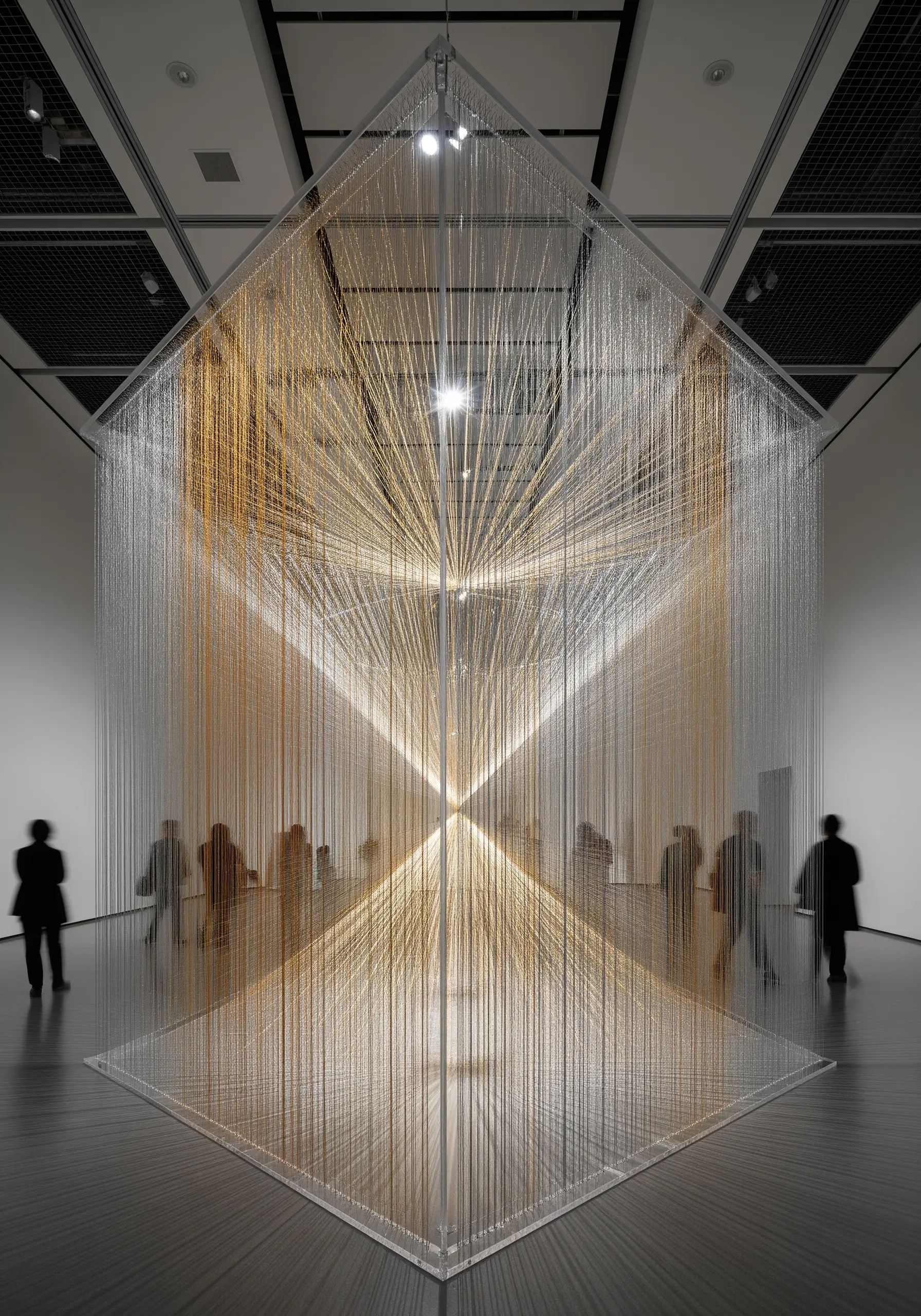 A large, room-sized installation made of thousands of vertical strands of metallic thread.