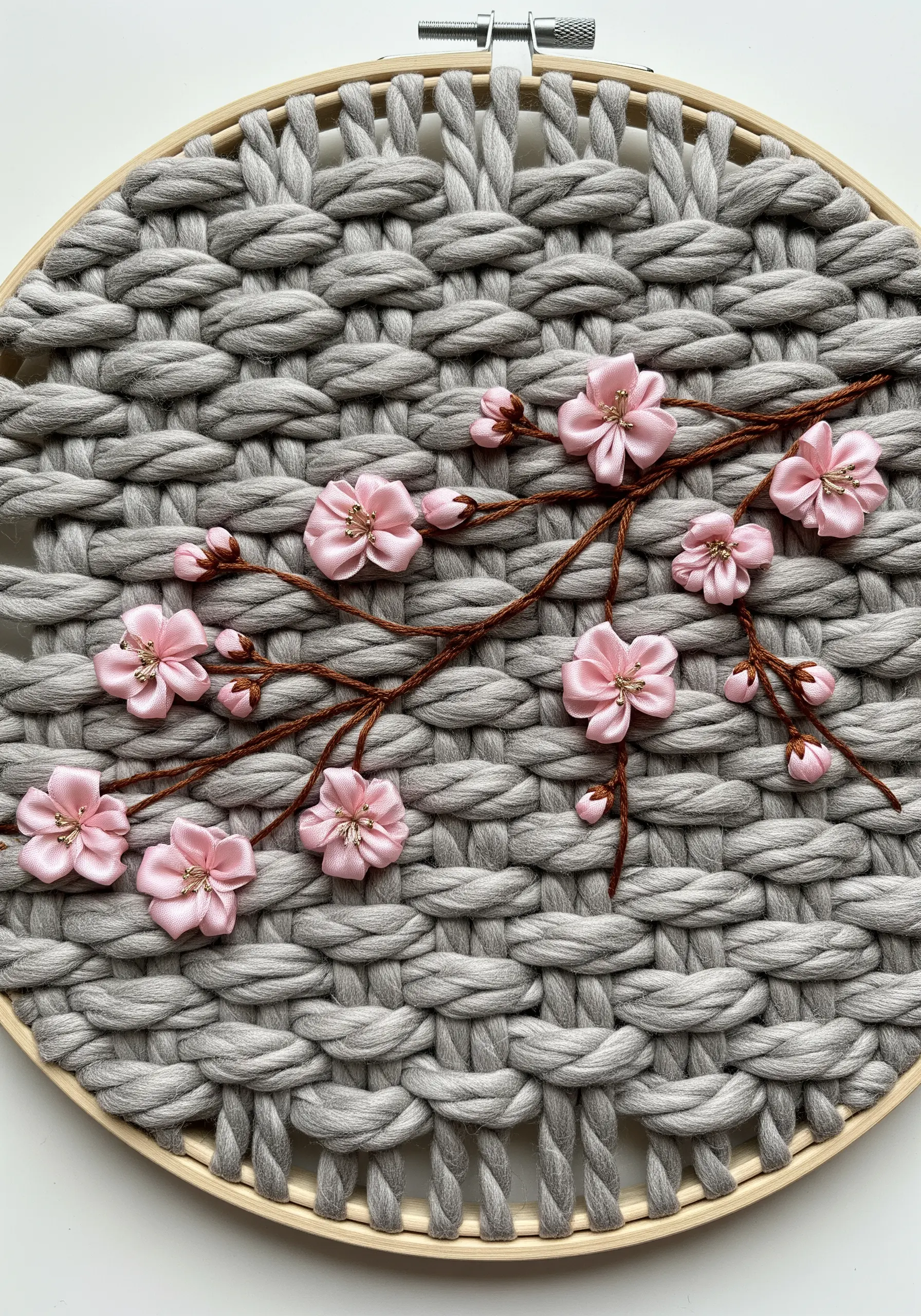 Pink ribbon embroidery cherry blossoms on a chunky grey woven background.