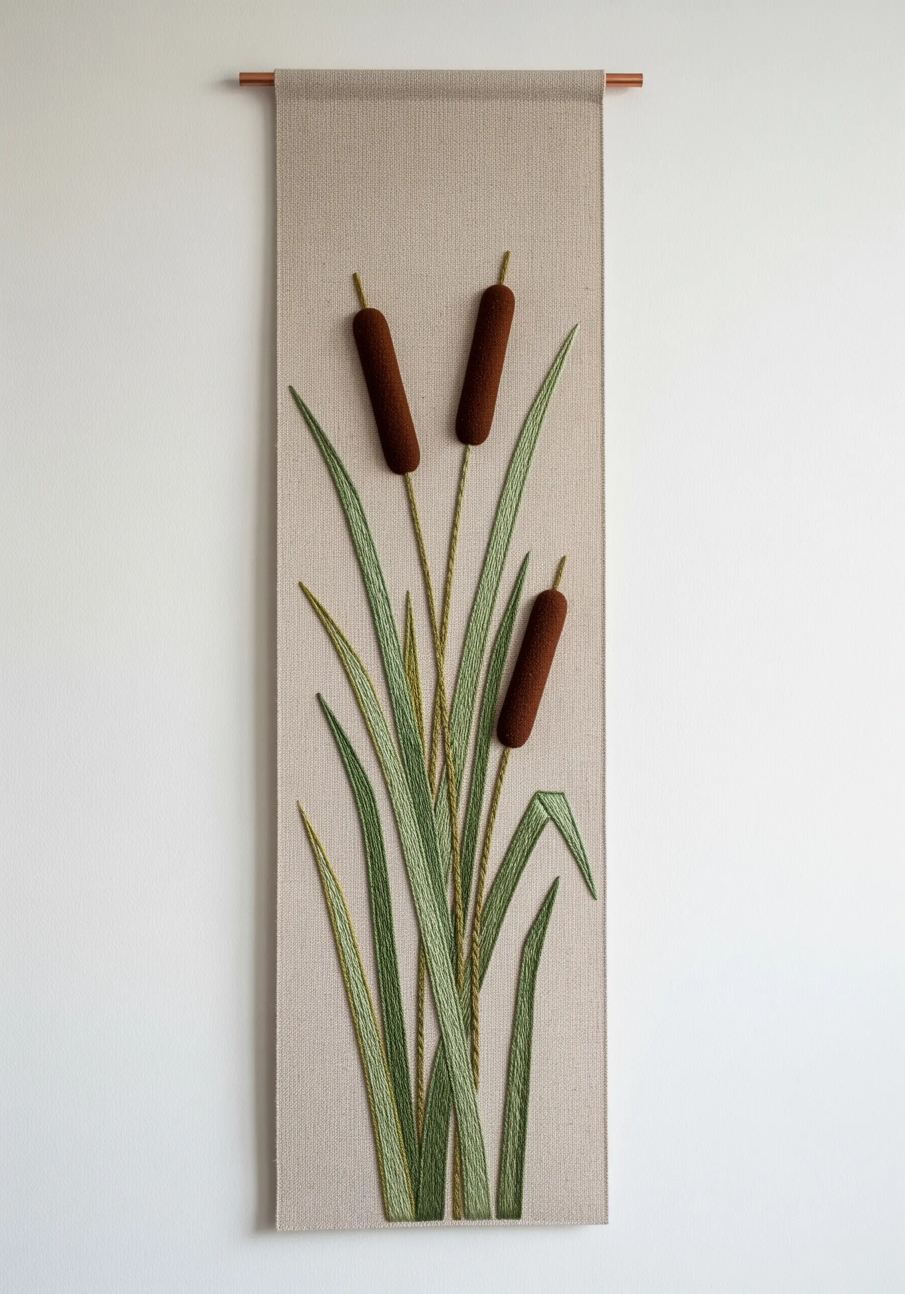 A minimalist wall hanging featuring cattails with plush, 3D stitched heads and sleek leaves.