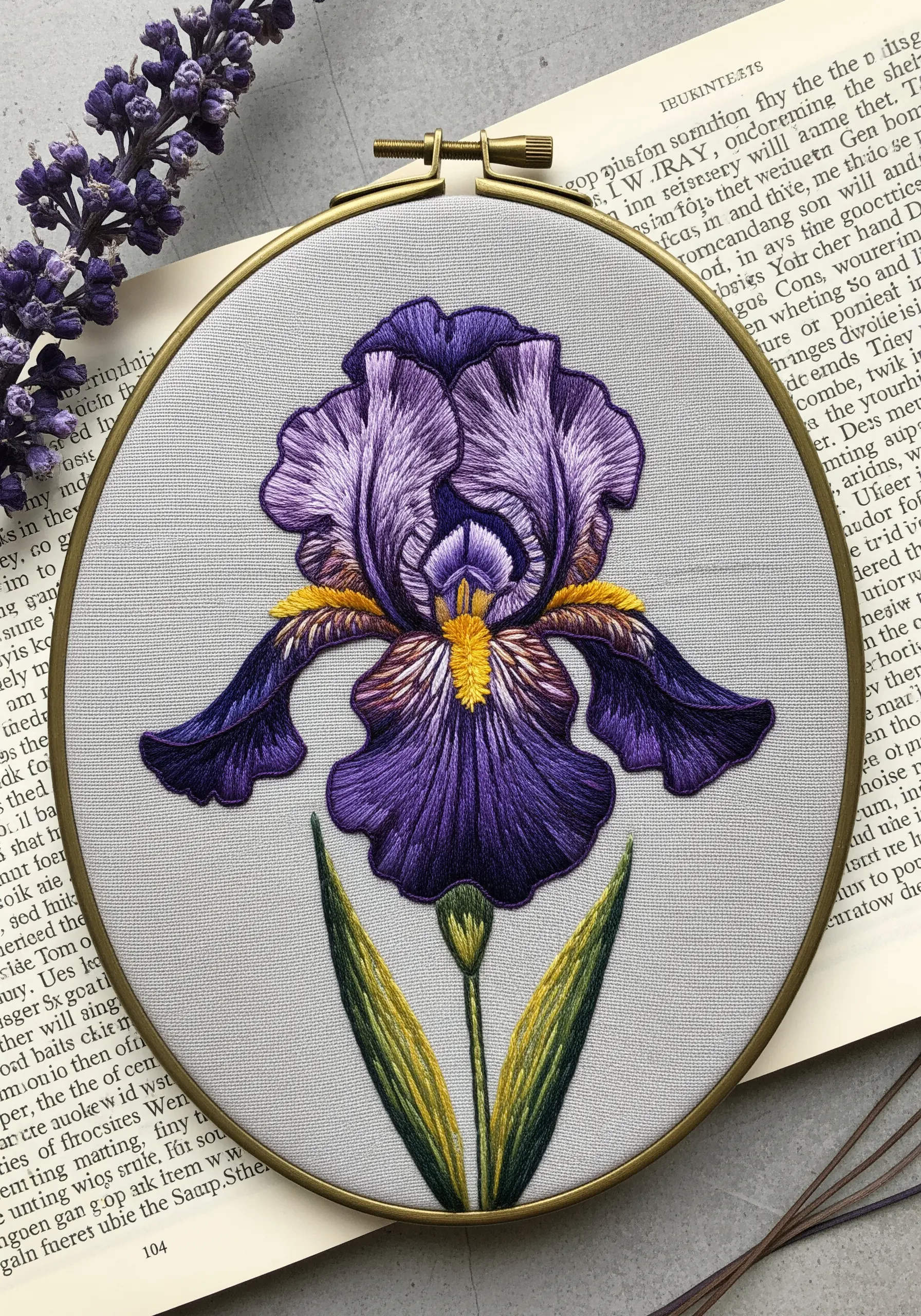 A detailed, thread-painted purple iris with dramatic petal textures on light grey fabric.