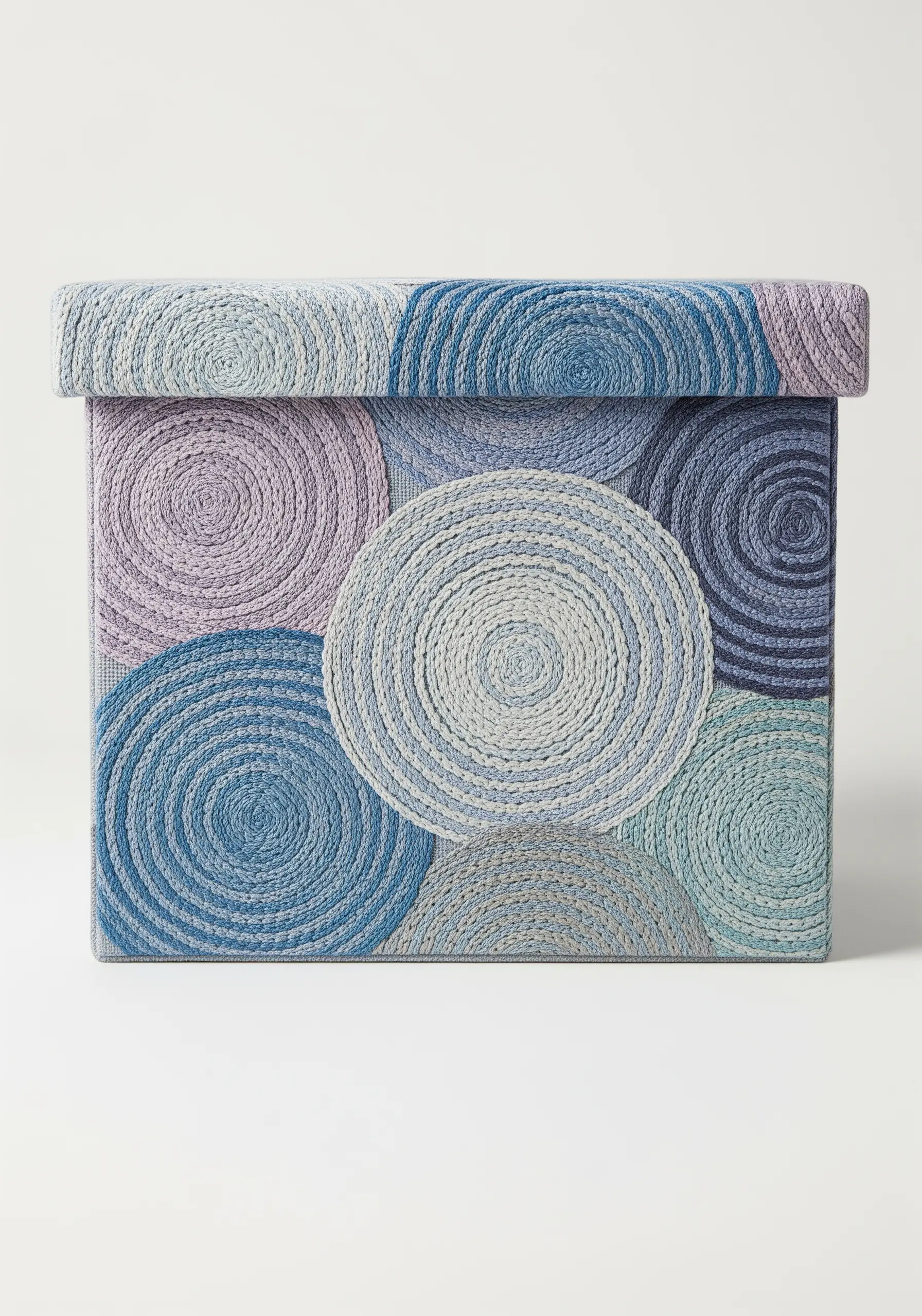 A fabric box covered in overlapping coiled circles of blue and purple thread.