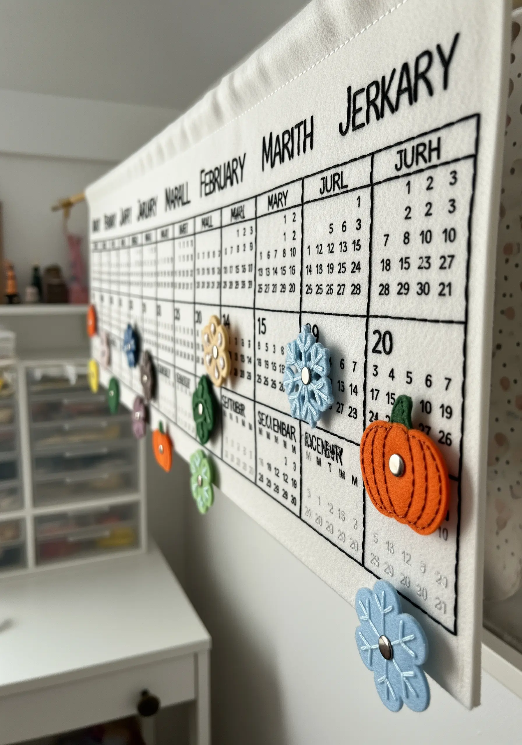 A handmade felt wall calendar with removable, colorful felt icons for each month.