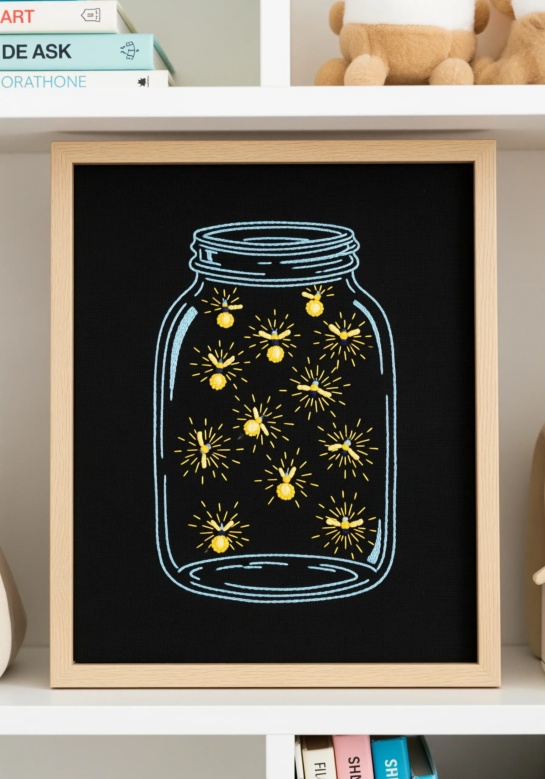 Embroidered fireflies glowing inside a mason jar, stitched on black fabric.